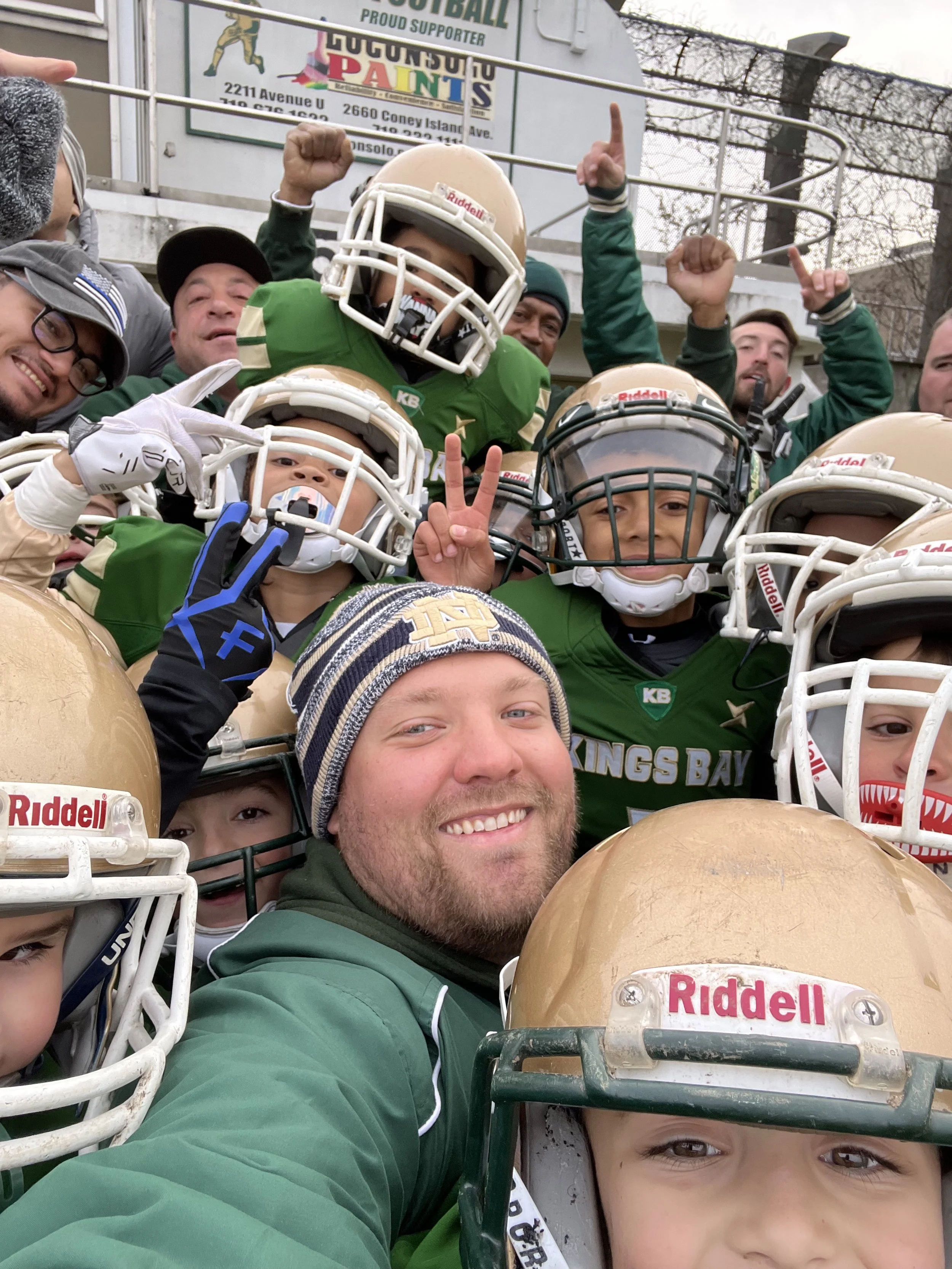 John McGuinness Founder of McGuinness Wealth Management MWM, and local youth football coach at Kings Bay Youth Organization, taking a picture with his team after a youth football game