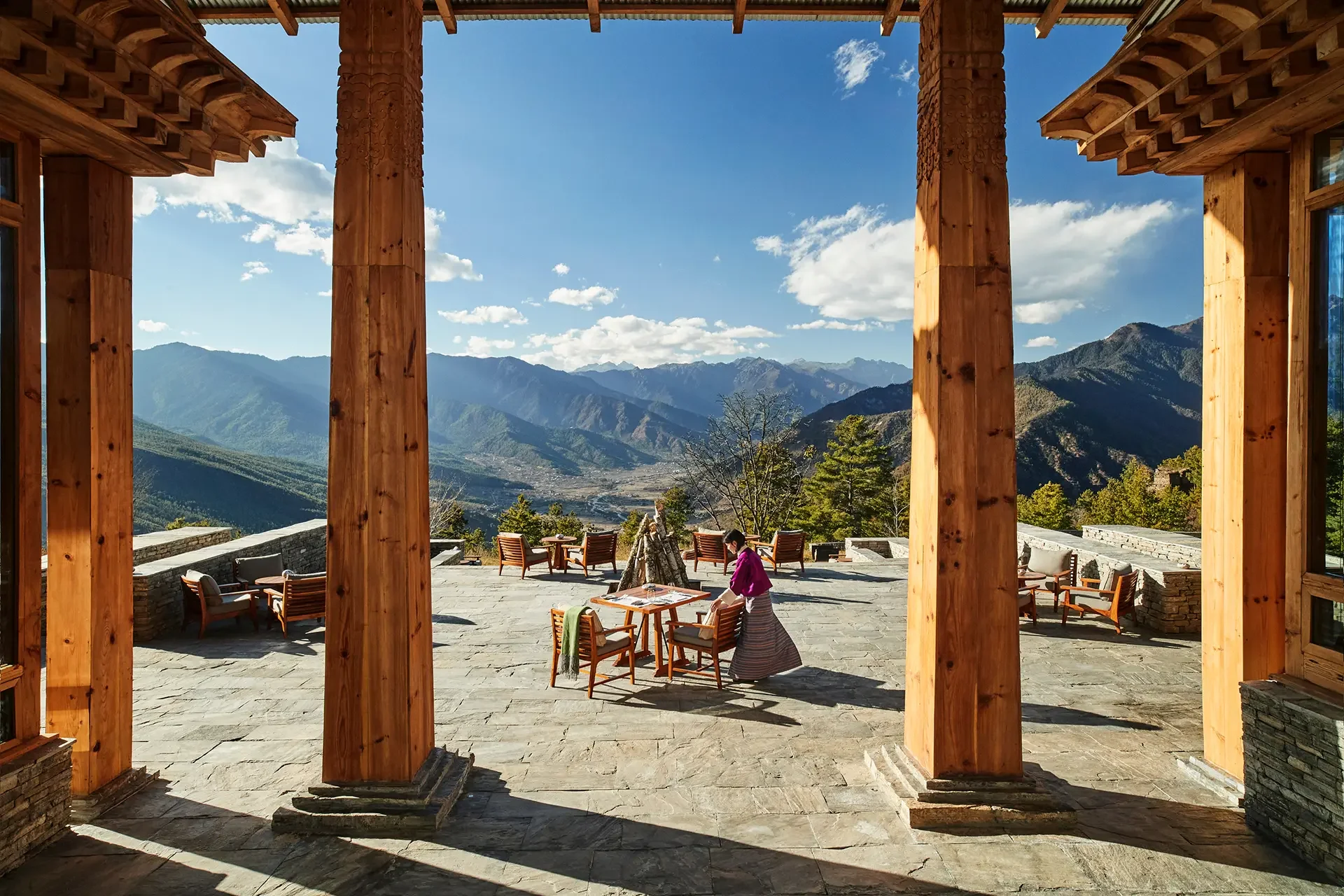 Outdoor patio with wooden columns and mountain view backdrop.
