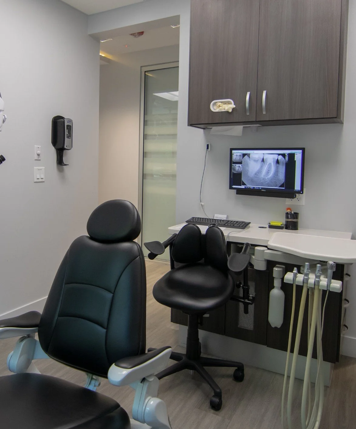 dental room with monitor installed on wall with hidden computer showing X-ray of teeth