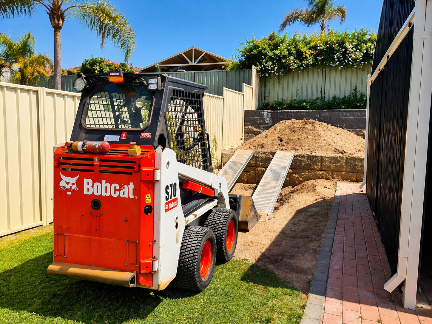 Bobcat loader in suburban yard setting.png