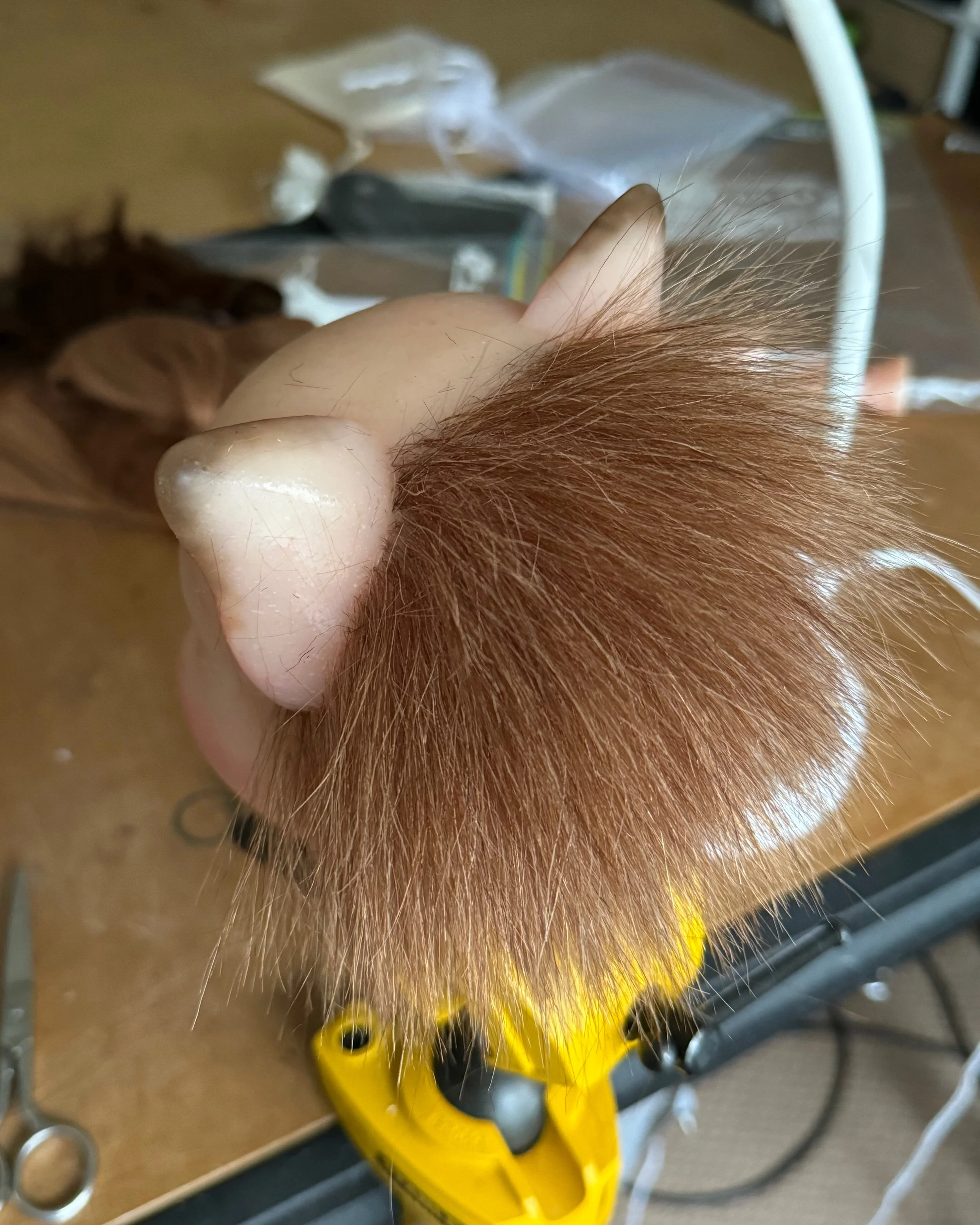Puppet head having hair punched into its silicone skin