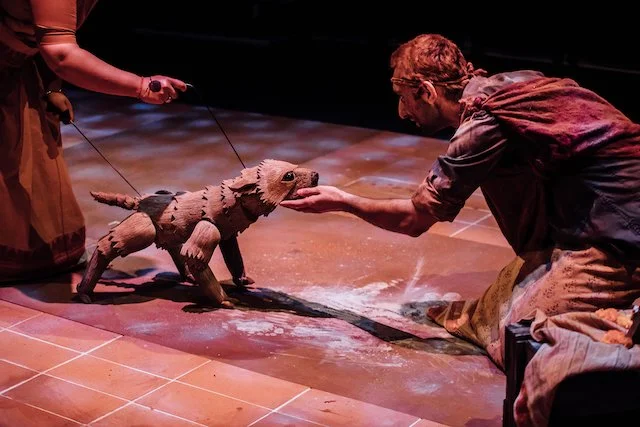 A scene from the play A Fine Balance with a dog puppet by Paul Lewis