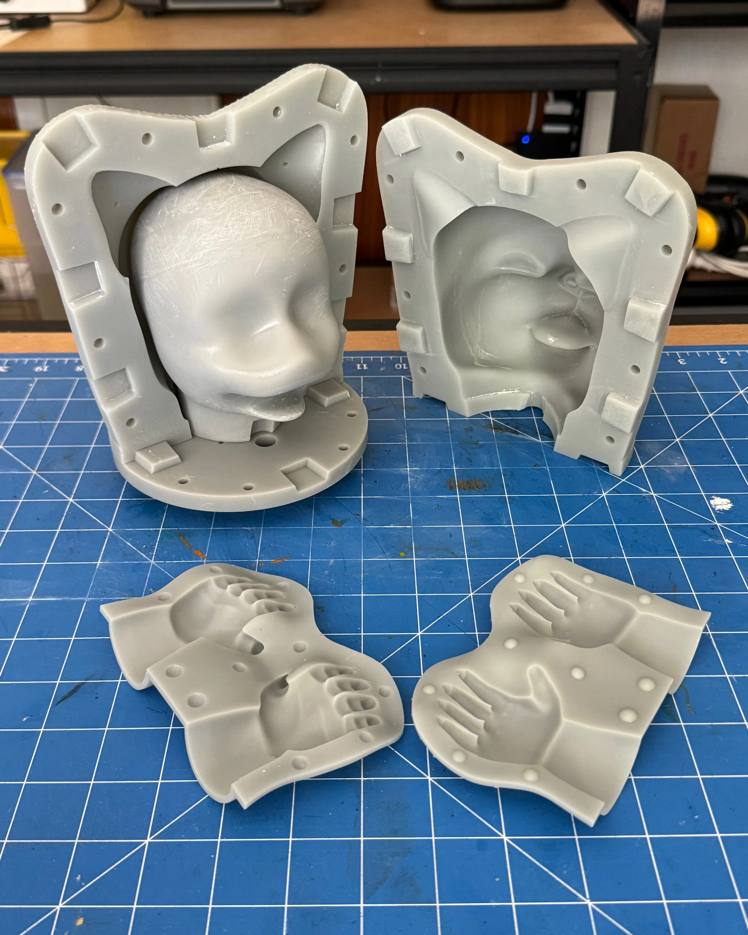 Silicone molds of a child's face and hands used for casting.