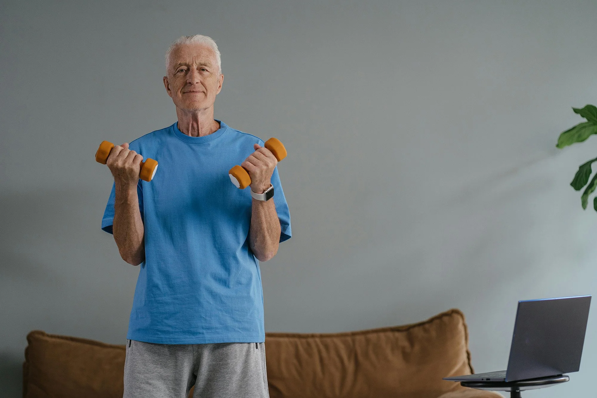 man holding two dumbbells as part of physiotherapy training to live his highest self