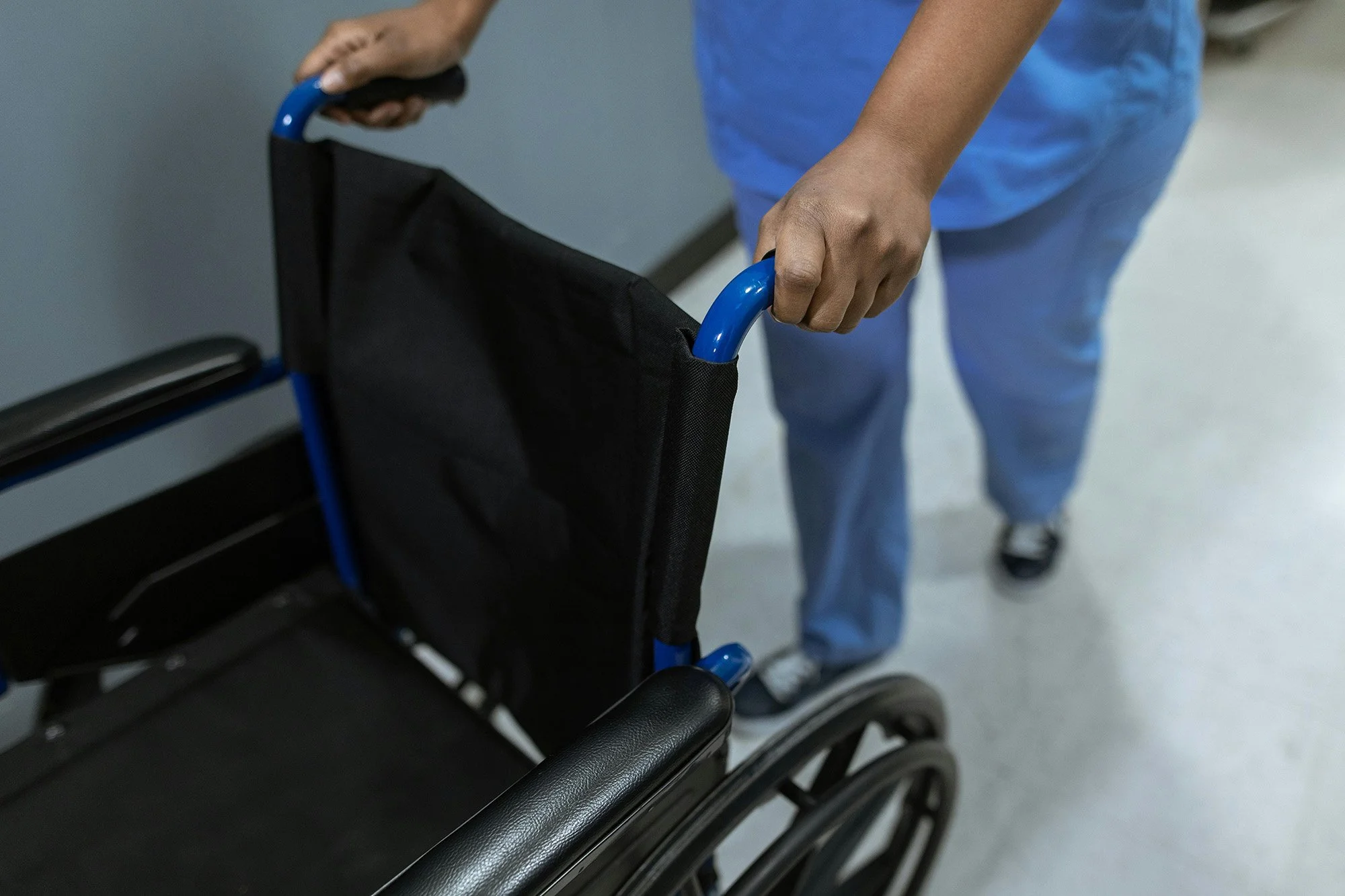 Physiotherapist pushing a wheelchair ready to support patients