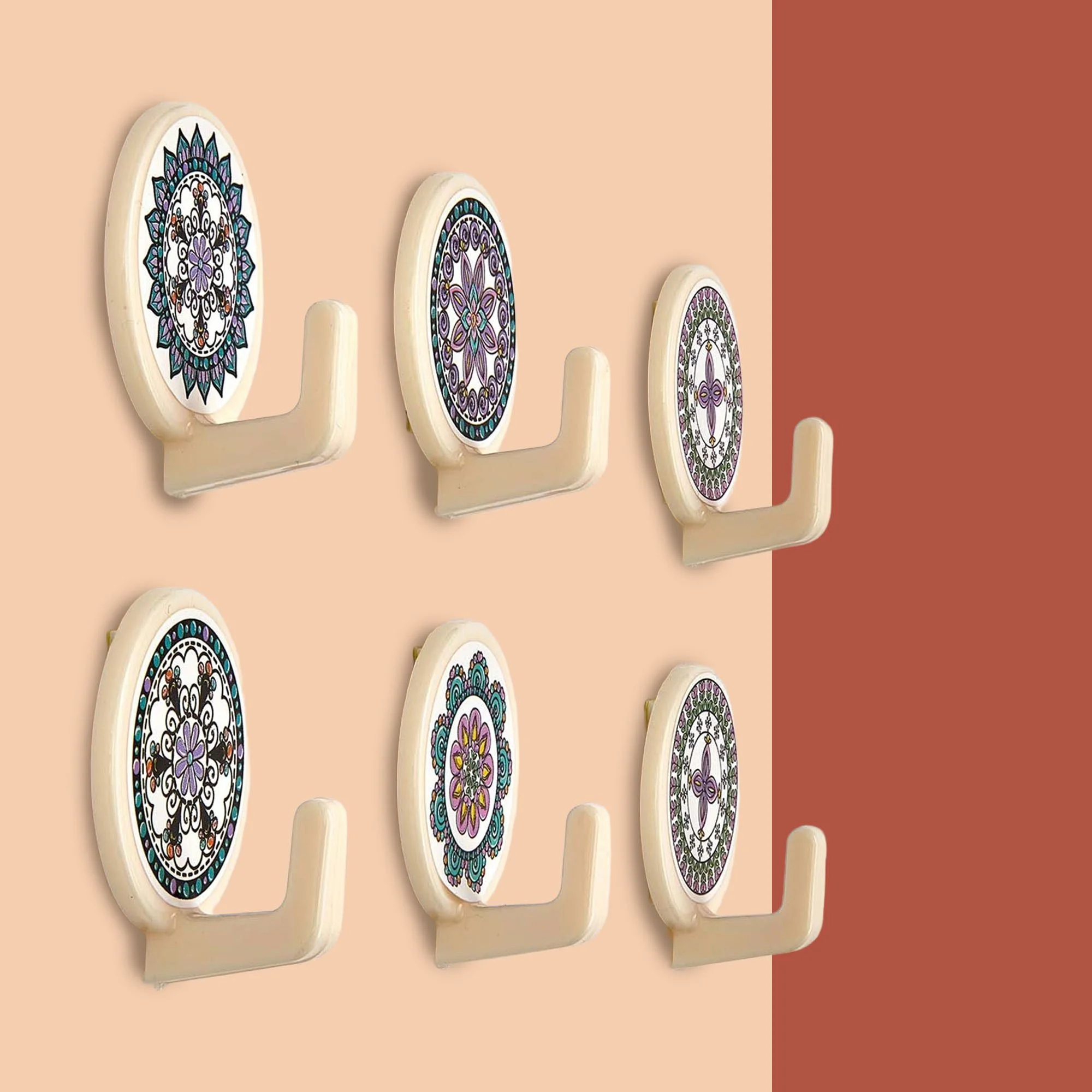 Decorative wall hooks with circular mandala designs, mounted on a tan wall with a brown accent wall to the right.