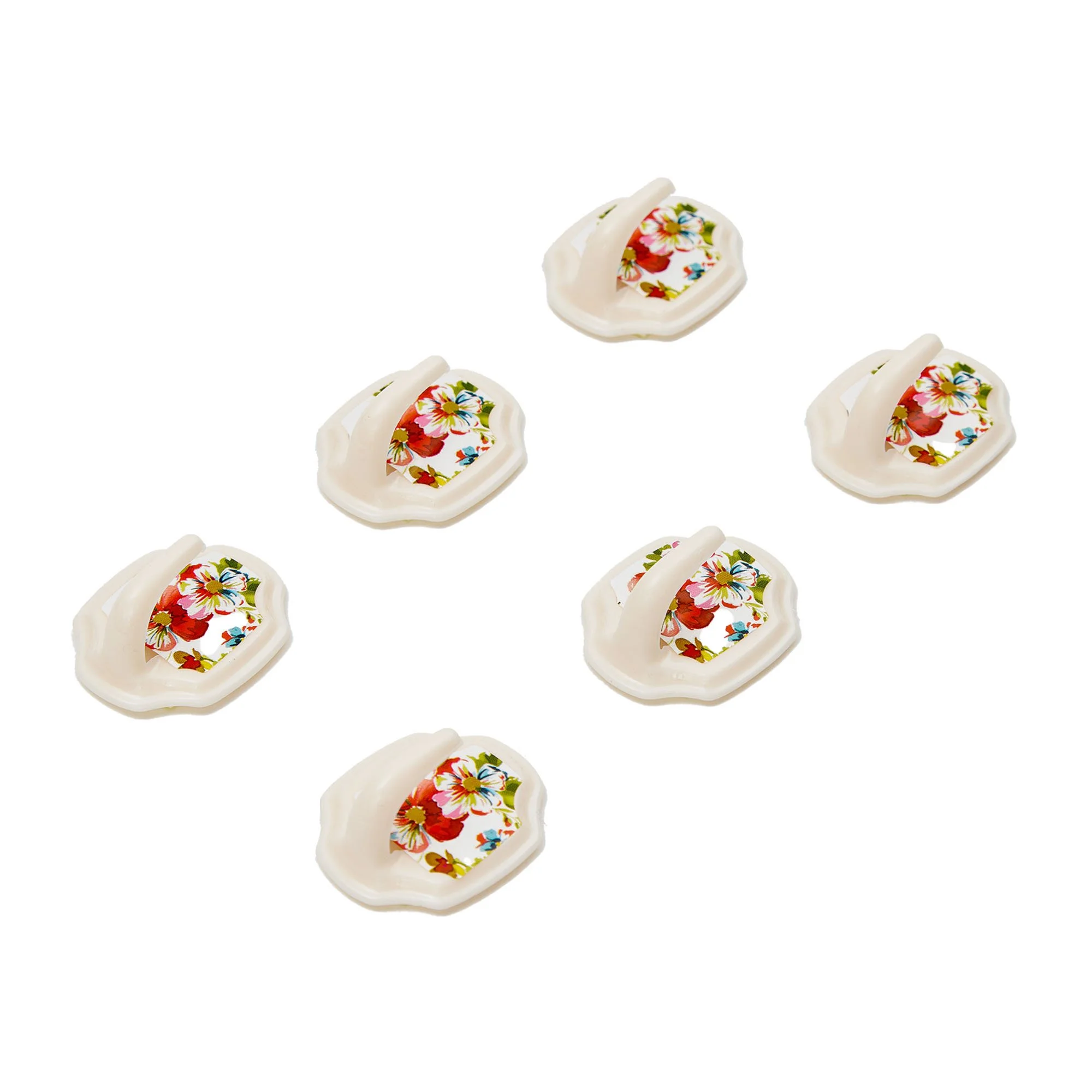 Several white seashell-shaped containers with colorful floral patterns inside, arranged in a scattered pattern on a white background.