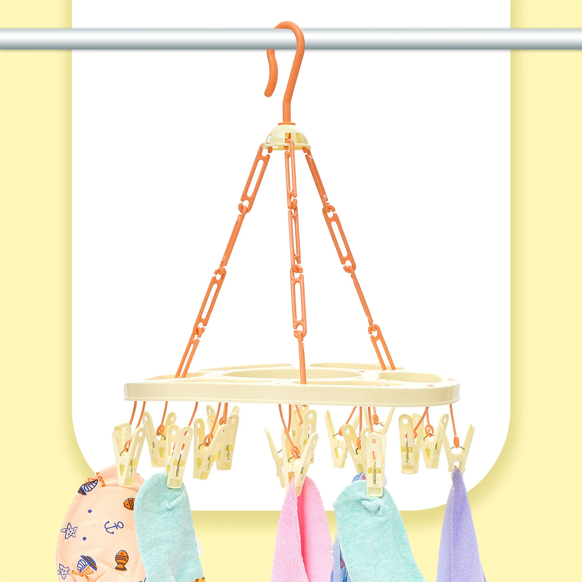 Colorful socks hanging on a clothesline with yellow clothespins against a yellow wall.