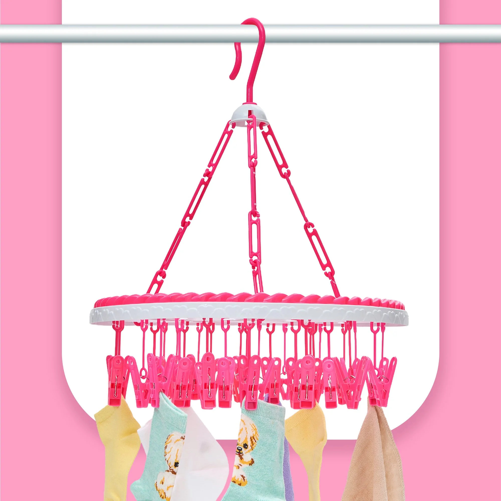 Pink hanging clothes rack with colorful socks hanging on it, set against a pink and white background.