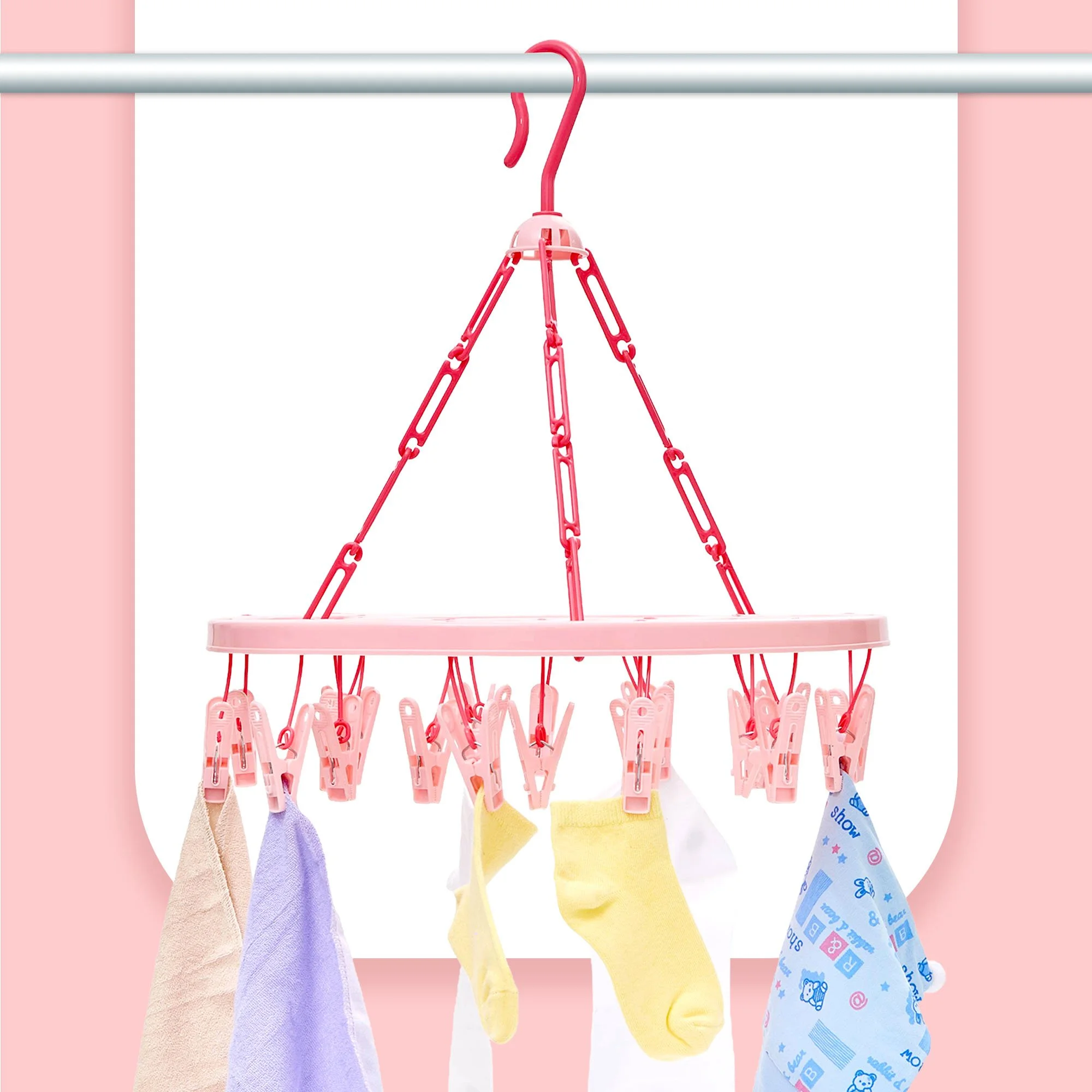 Pink laundry drying rack with five colorful socks hanging from clothespins.