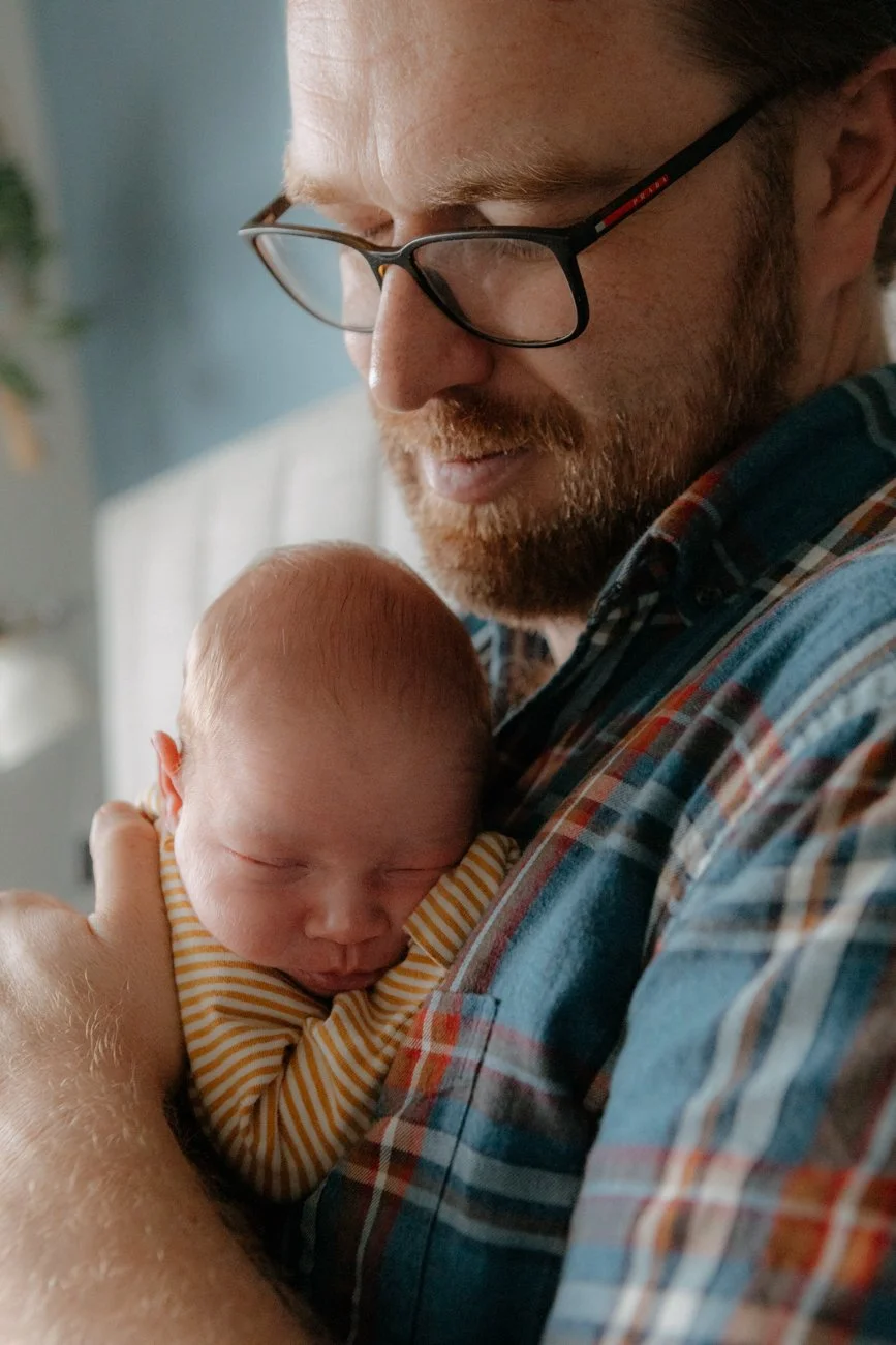 family-portraiture-father-holding-newborn-on-bed.001.jpg