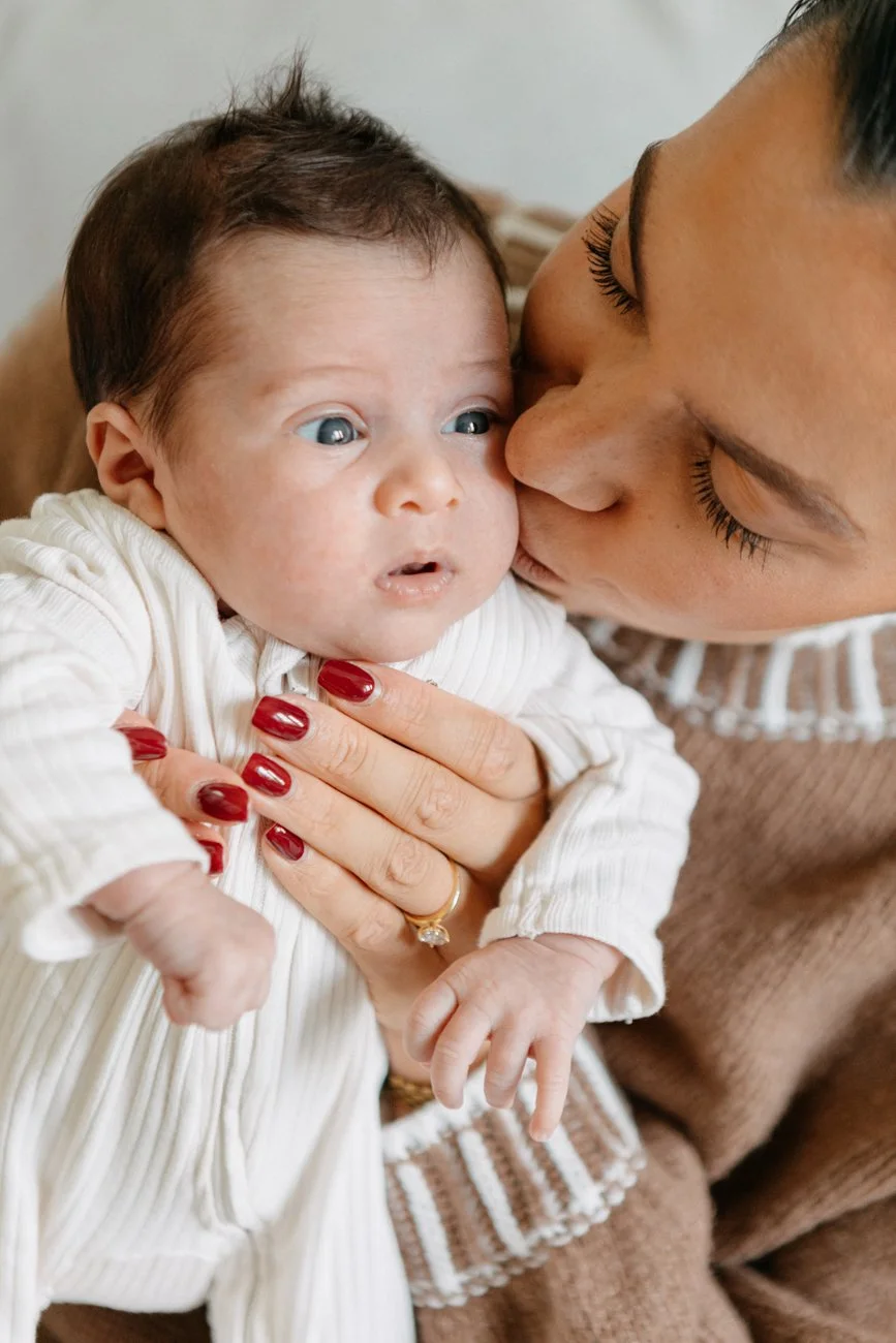 family-portraiture-mother-kissing-newborn-couch.001.jpg