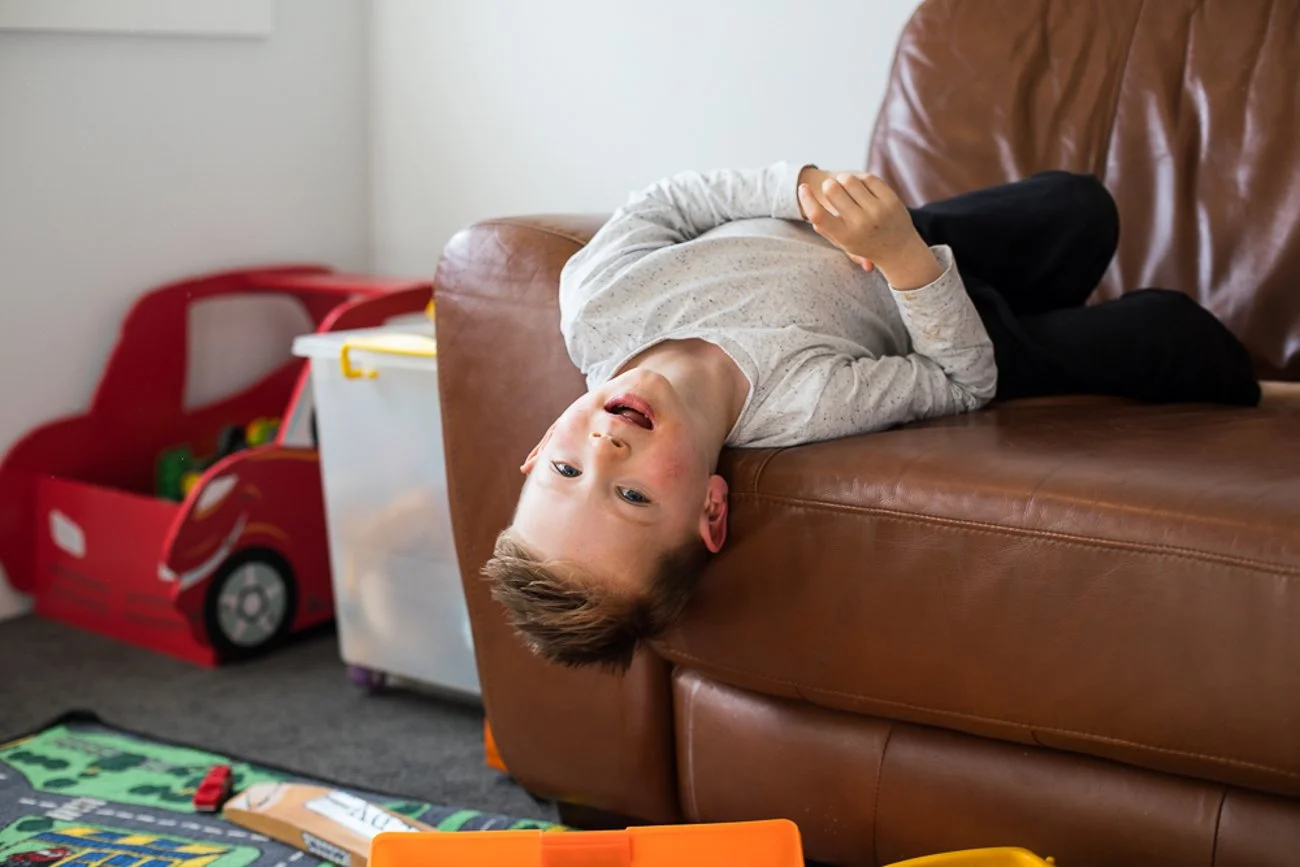 family-portraiture-child-backwards-on-couch.001.jpg