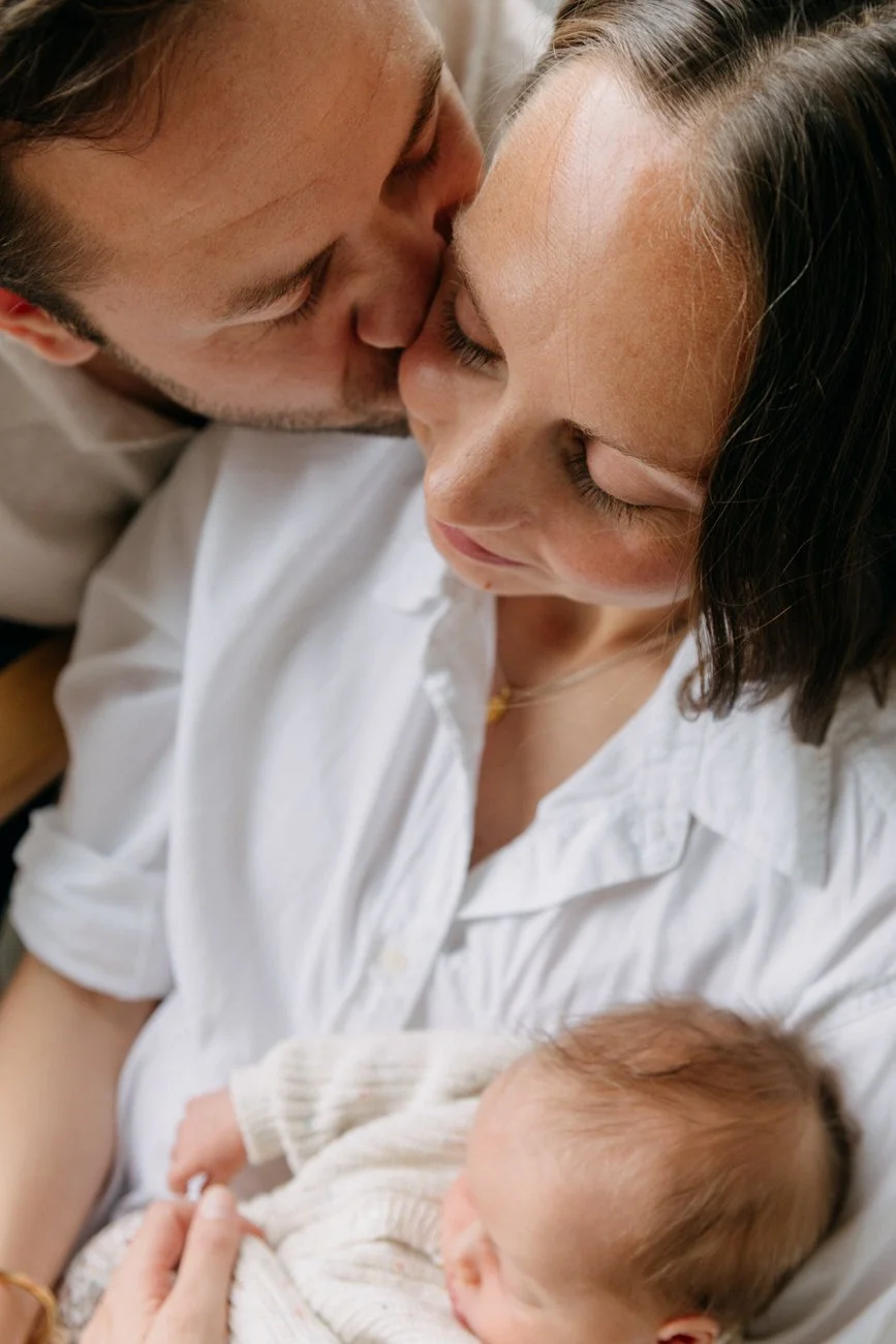 family-portraiture-father-kissing-mother-newborn-in-arms.001.jpg