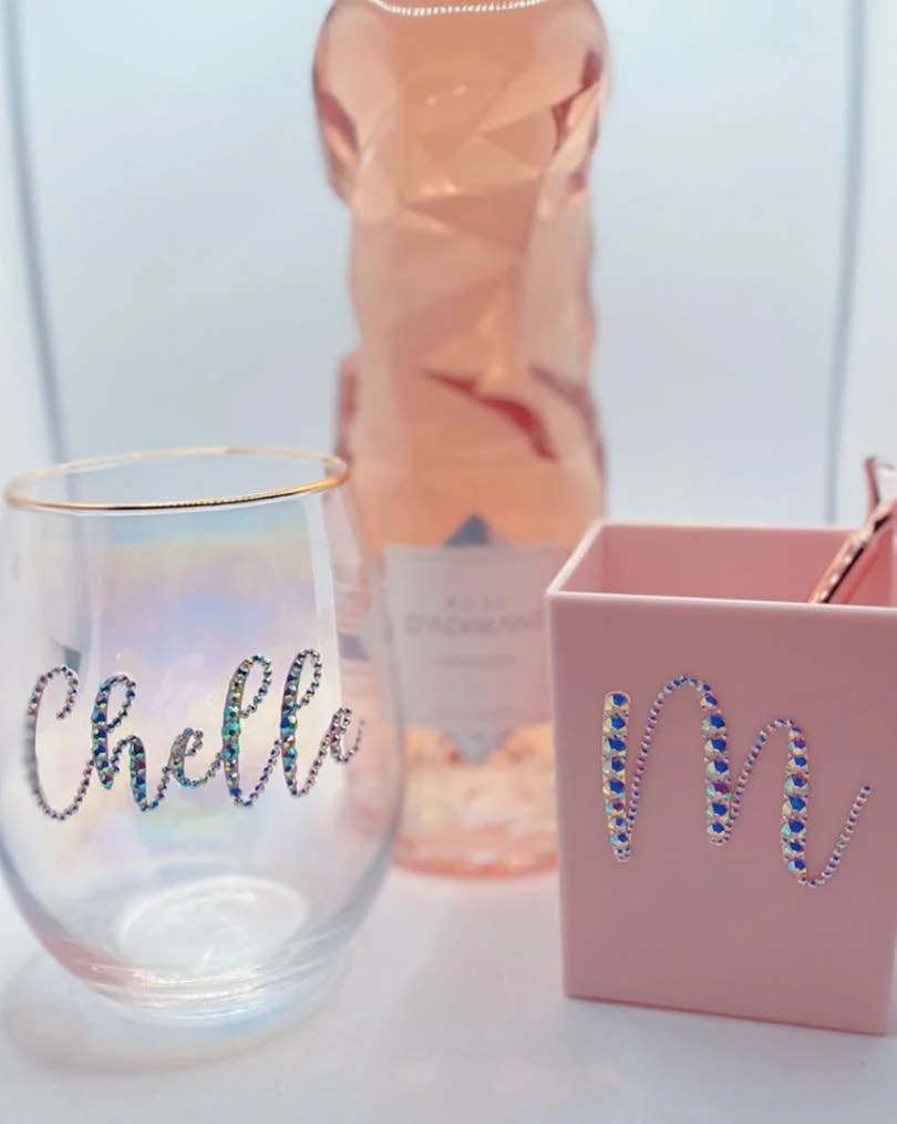 A clear glass tumbler with the word 'Chill' in rhinestones, a pink vase with a faceted surface, and a pink box with the word 'Mum' decorated with rhinestones.