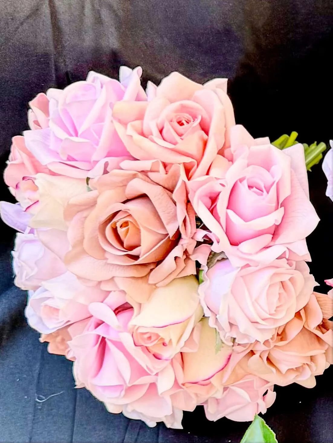 A bouquet of pink roses on a dark background.