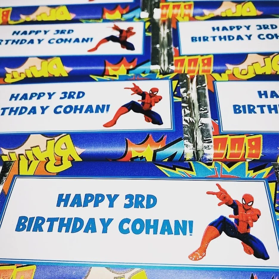 Colorful birthday party favors with a Spider-Man figure and a message that says 'Happy 3rd Birthday Cohan'.