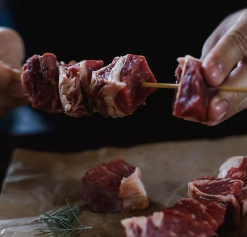 Nogen skære kødstykker på et skærebræt.