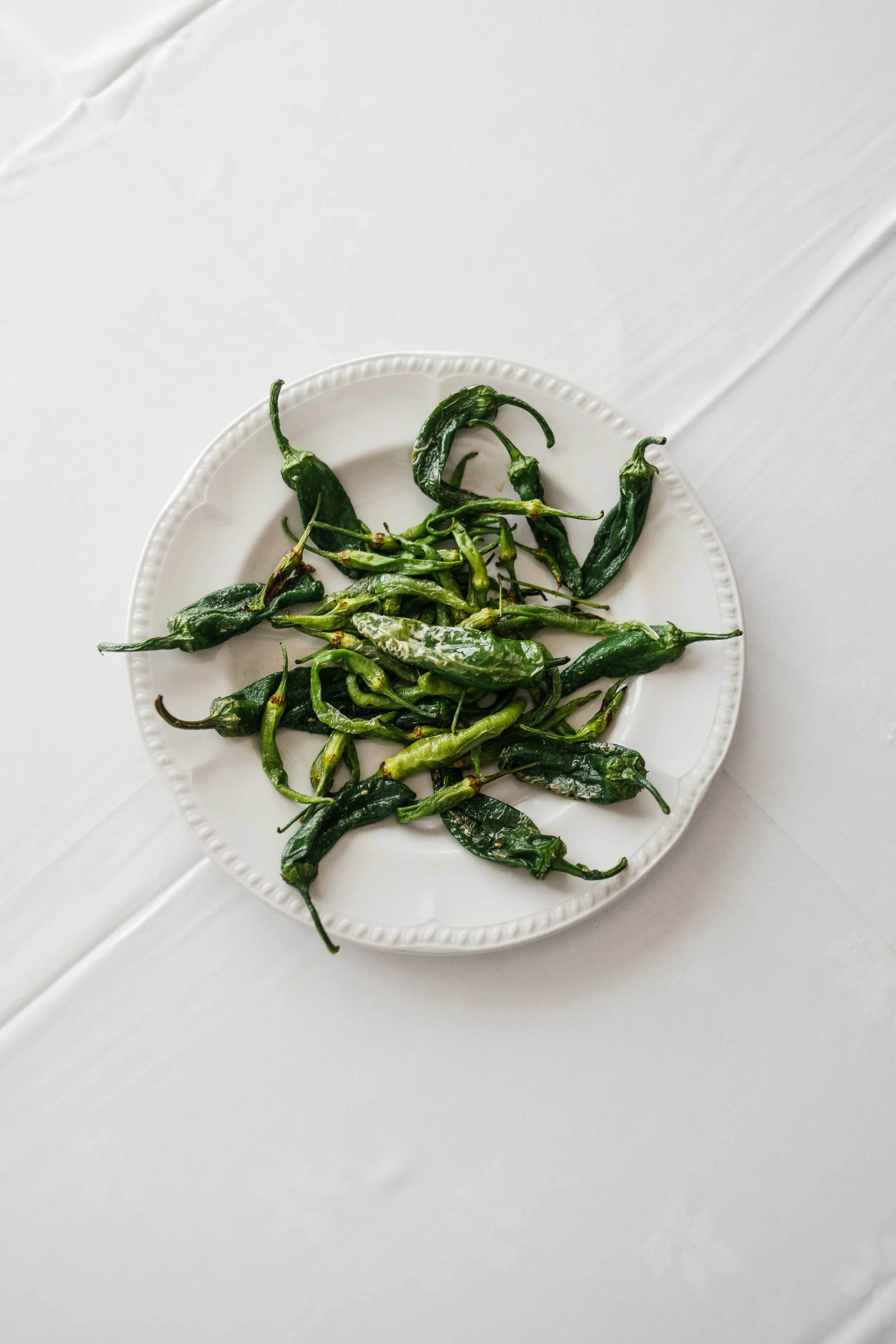 Pimientos verdes sobre un plato blanco.
