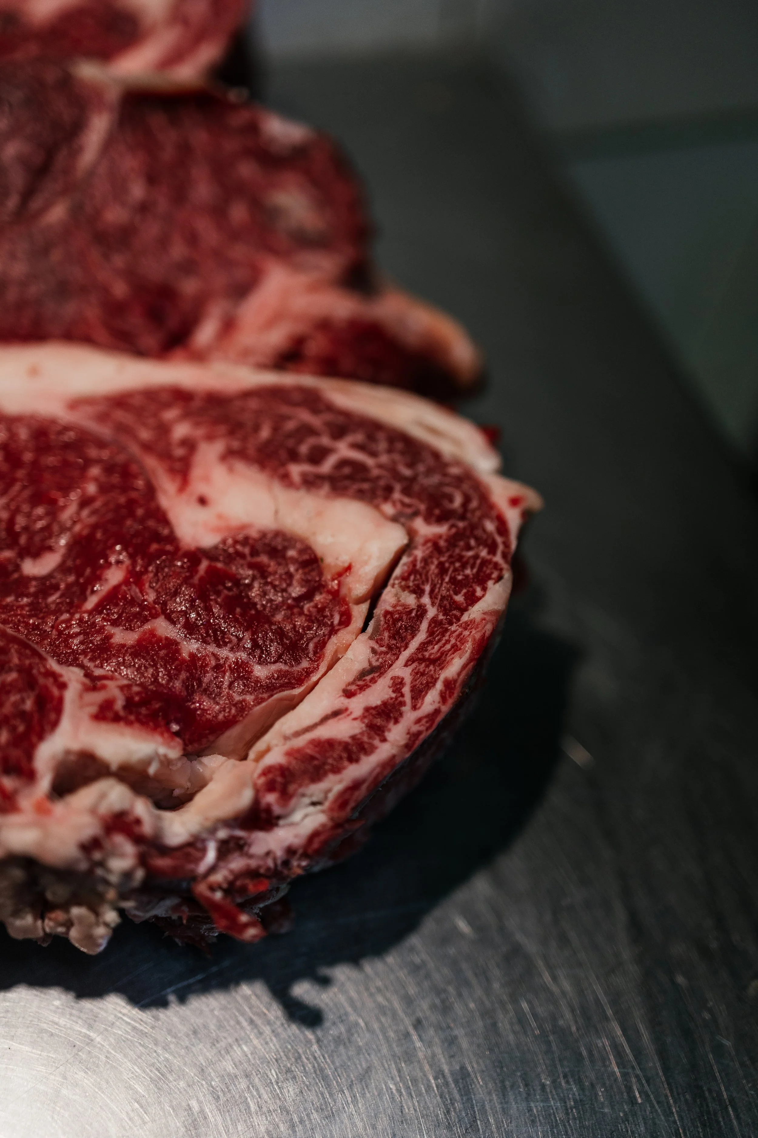 Carne de res con grasa y veteado en una tabla de cocina.