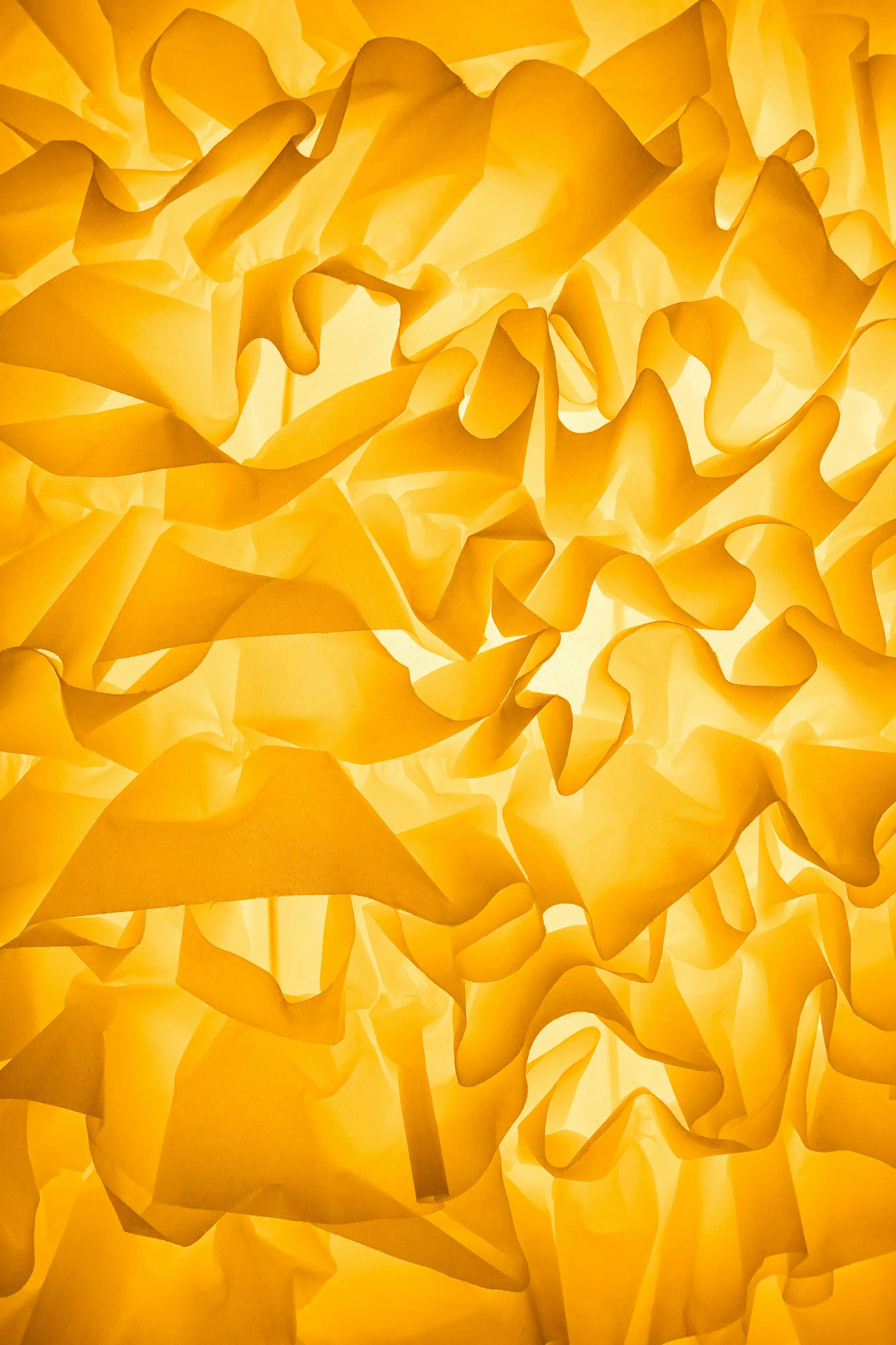 Close-up of a yellow paper lantern with crumpled, folded paper design.