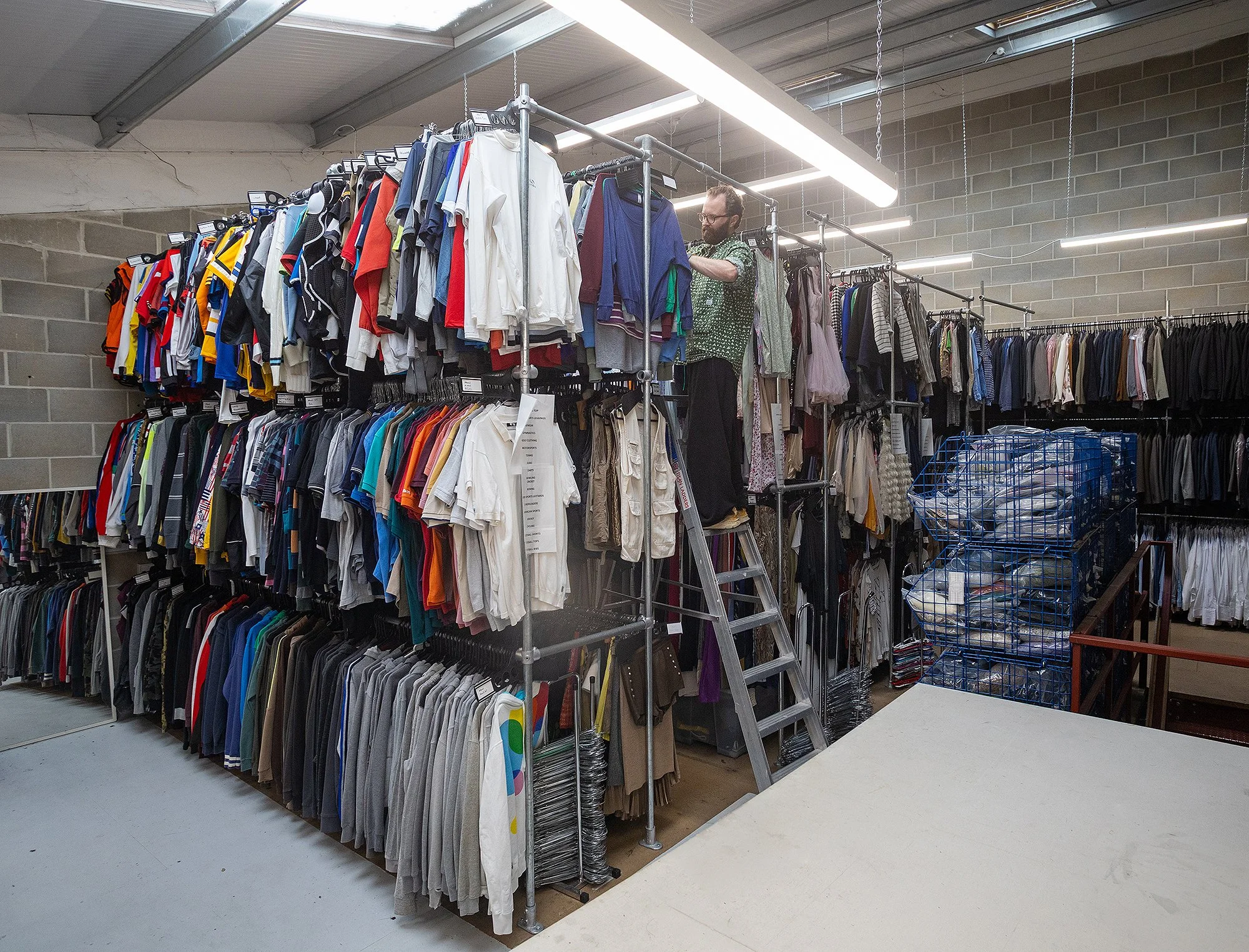 Costume designer selecting contemporary wardrobe pieces in a well-organised East London costume rental facility