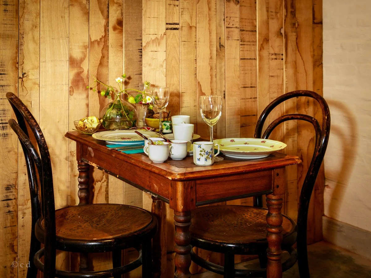 Een eettafel met servies, glazen, borden, kommen en bestek, in het Eetkaffee van 't Goed ter Heule