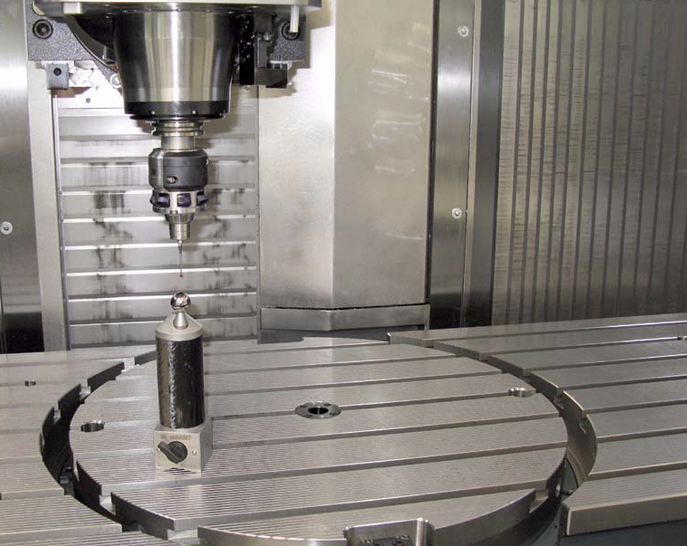 Close-up of a CNC machine drill preparing to machine a metal workpiece mounted on its rotary table.