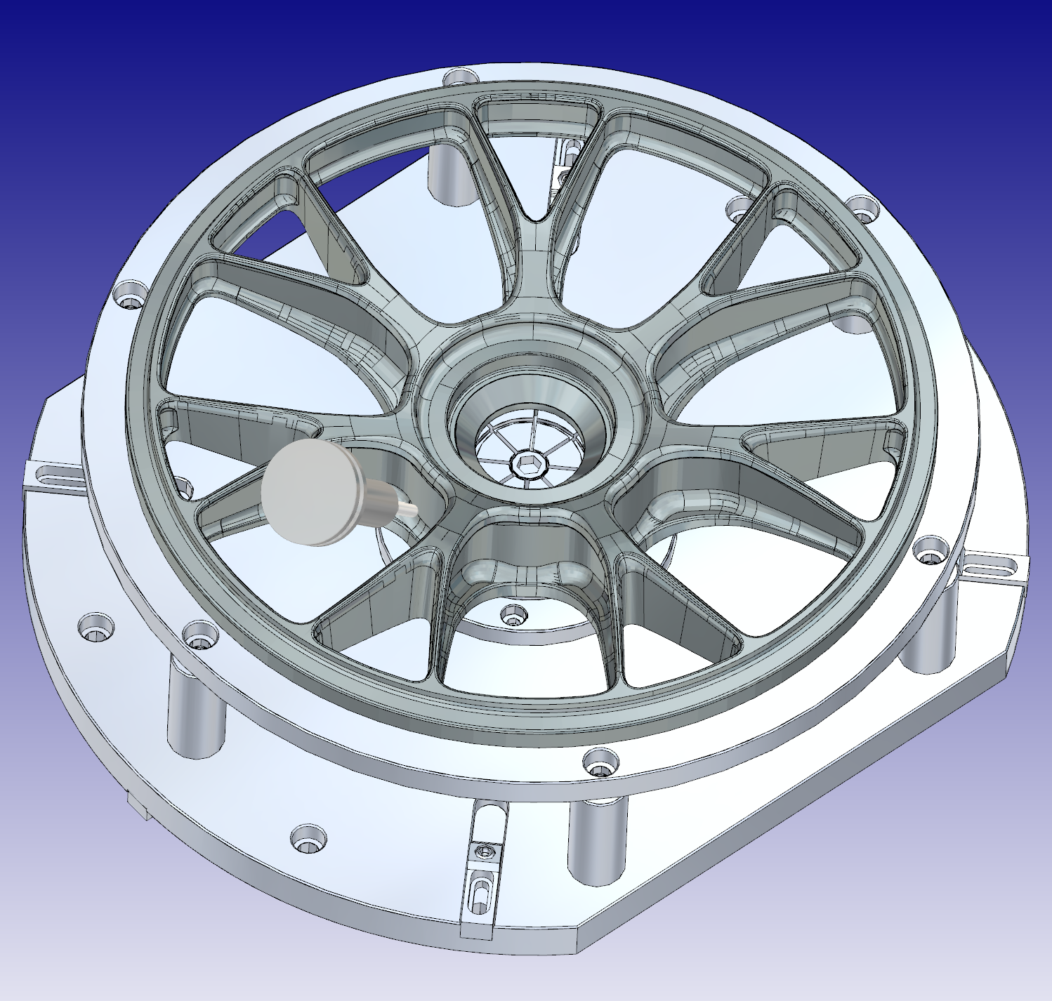 3D CAD rendering of a mechanical part, possibly a wheel or rotor, with a central hub, spokes, and a surrounding outer ring, mounted on a rectangular base.