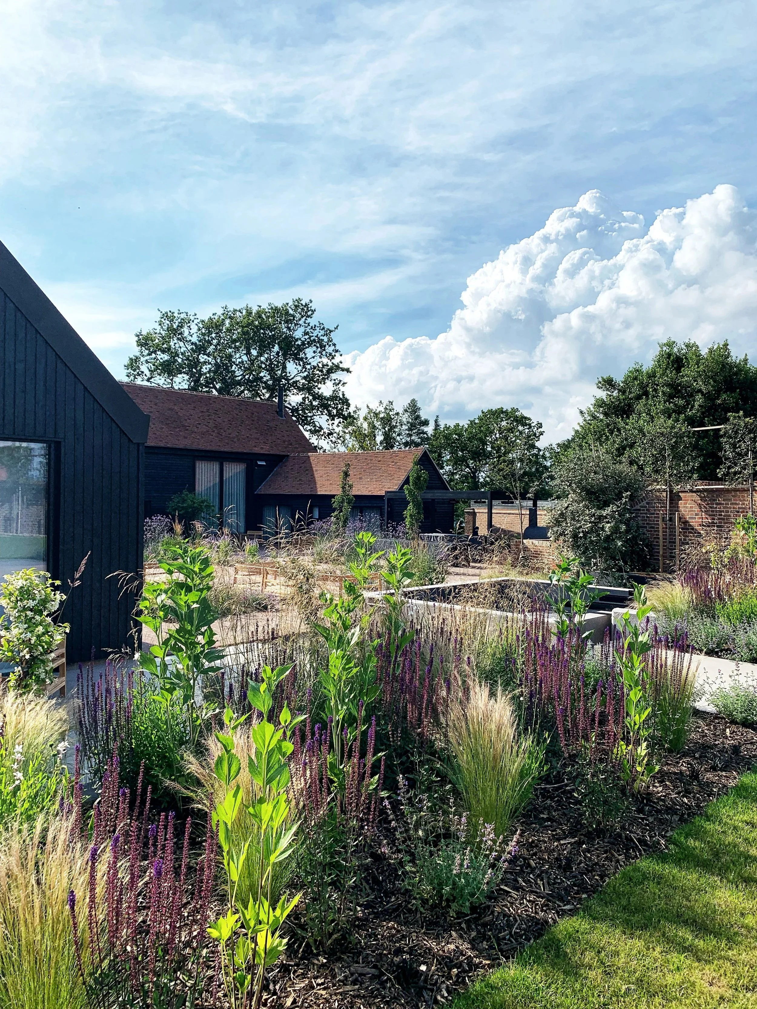 This contemporary garden was designed to be in keeping with the contemporary style of the barn.  A very large courtyard, broken up into sections for entertaining, with a large bespoke water feature.
