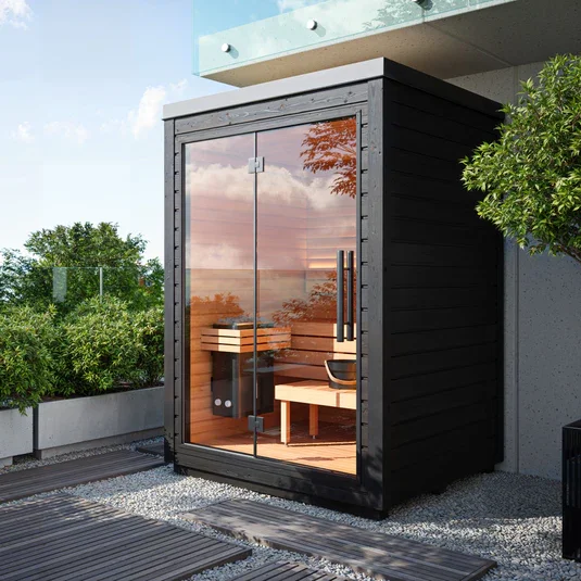Black wooden outdoor sauna with path and planting in Sussex