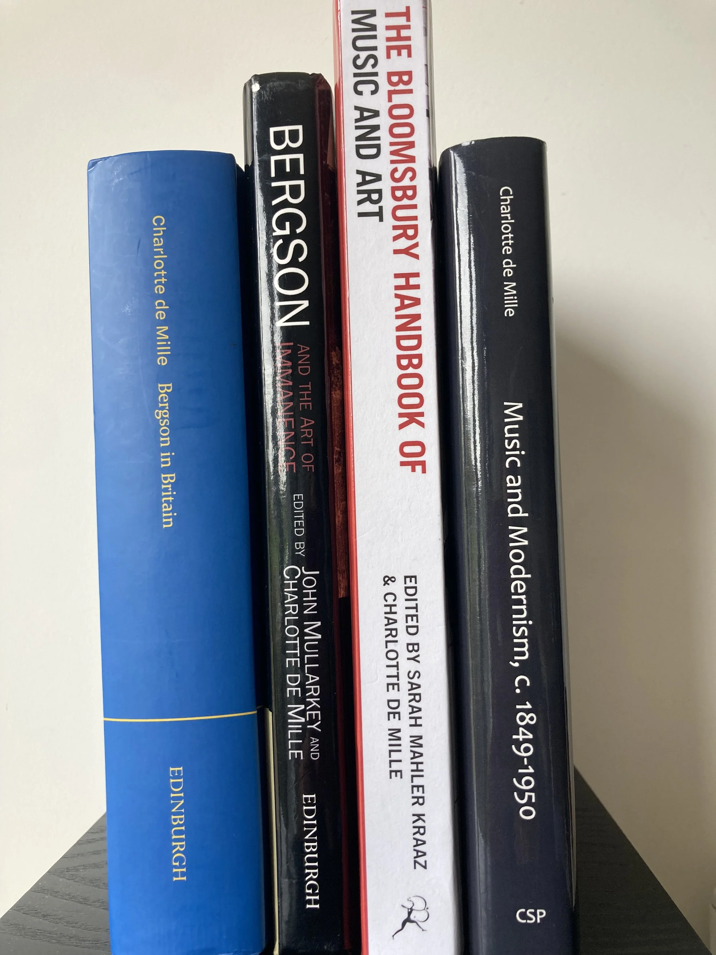 Books stacked vertically, including titles like 'The Bloodsupply of Music and Art', 'Berenson', and 'Charlotte de Mille'.