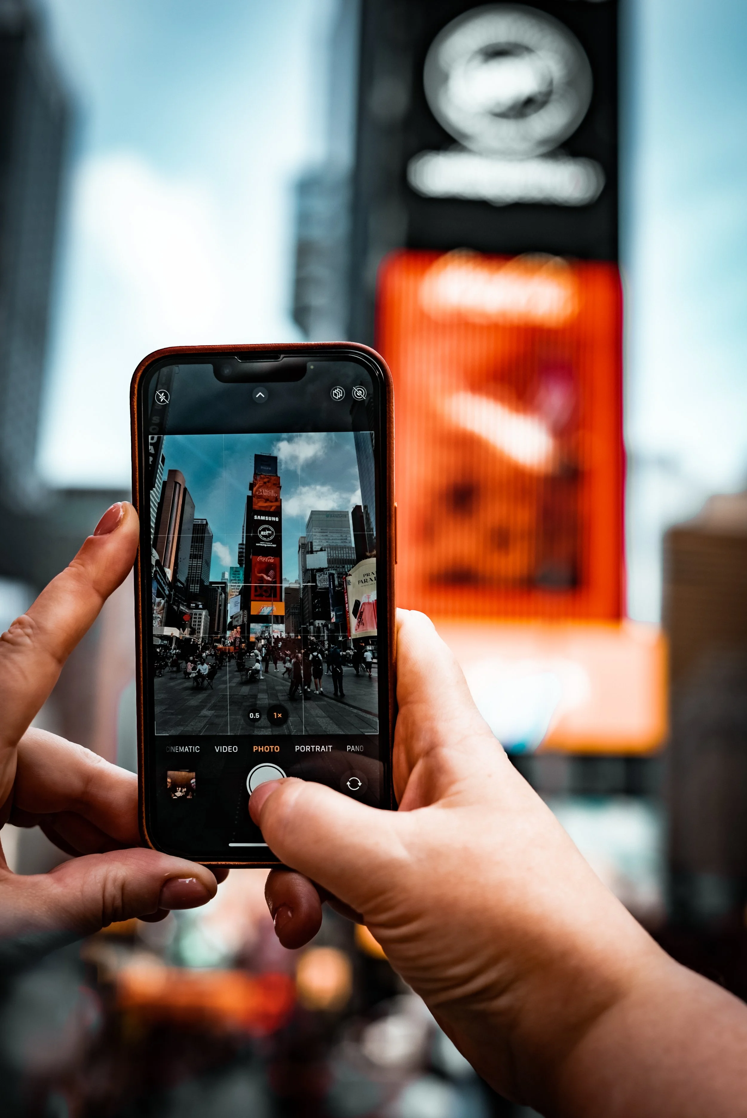 Person taking a photo of Times Square in New York City with a smartphone camera.