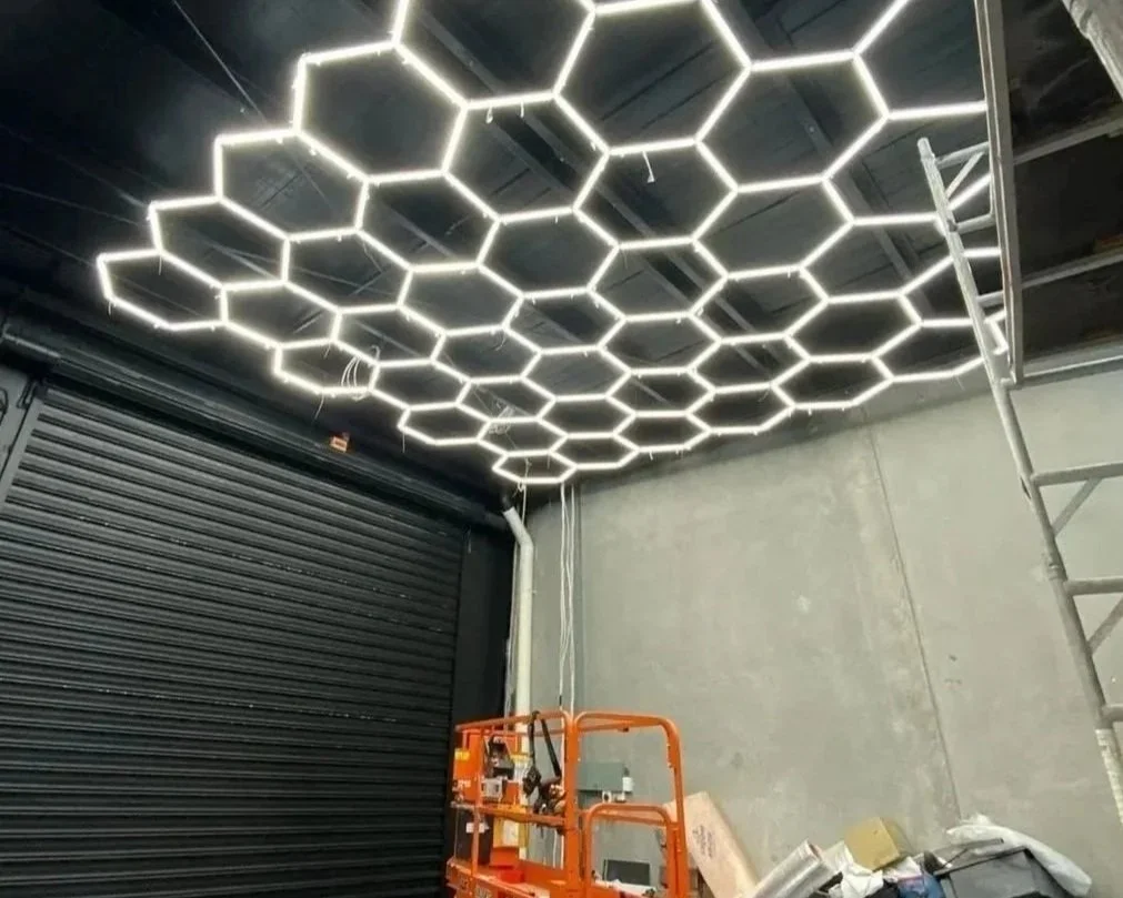 Ceiling with illuminated honeycomb-shaped LED lights in an industrial or garage setting