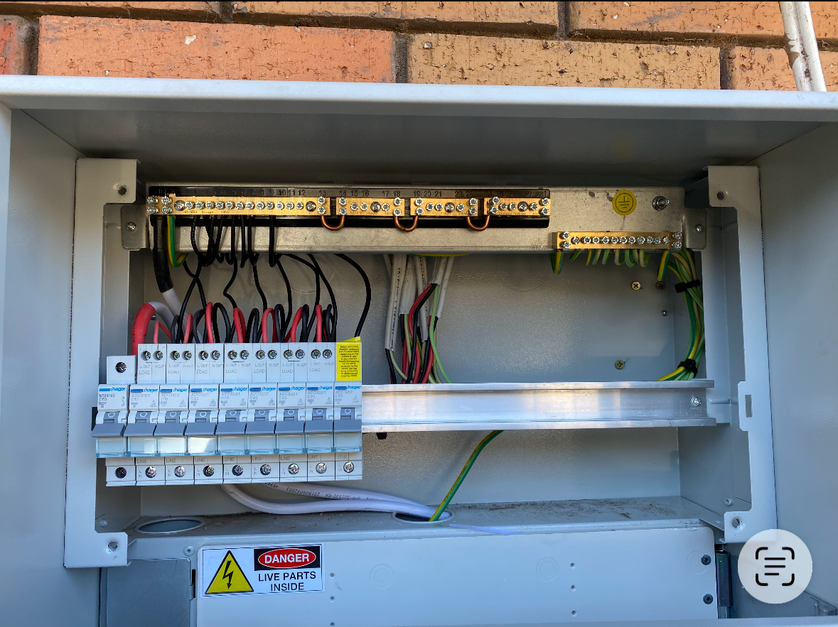 Inside an electrical panel with wiring, circuit breakers, and terminal blocks.