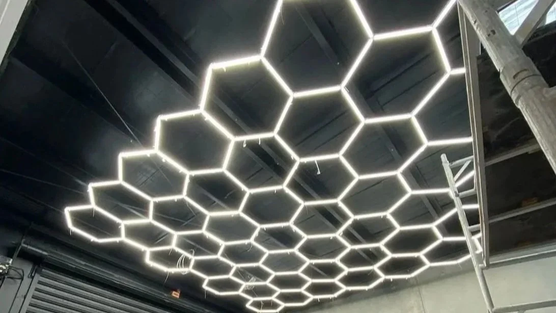 Ceiling with hexagon LED light fixtures in a modern interior space.