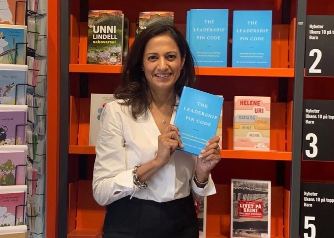 Dr. Nashater Deu Solheim holding The Leadership PIN Code in a bookshop