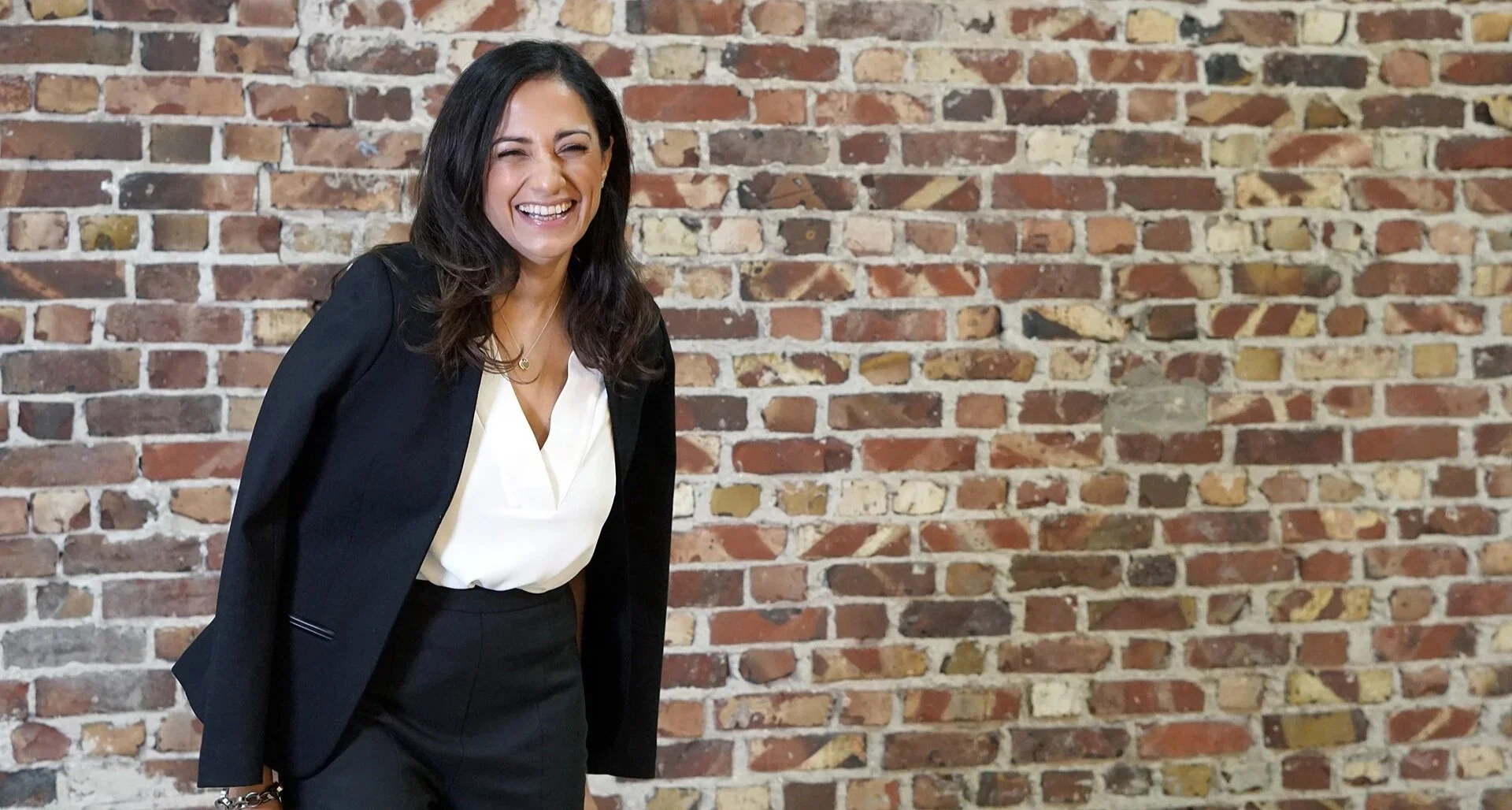 Dr. Nashater Deu Solheim smiling in front of a brick wall