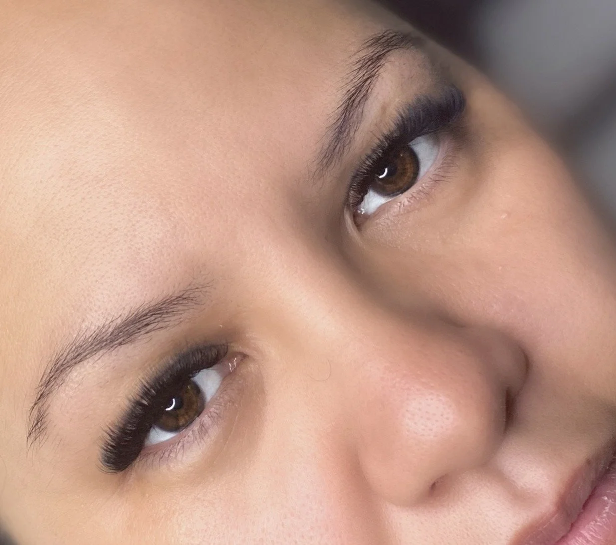 Close-up of a woman's eyes, showcasing a goegeous set of russian volume eyelash extensions