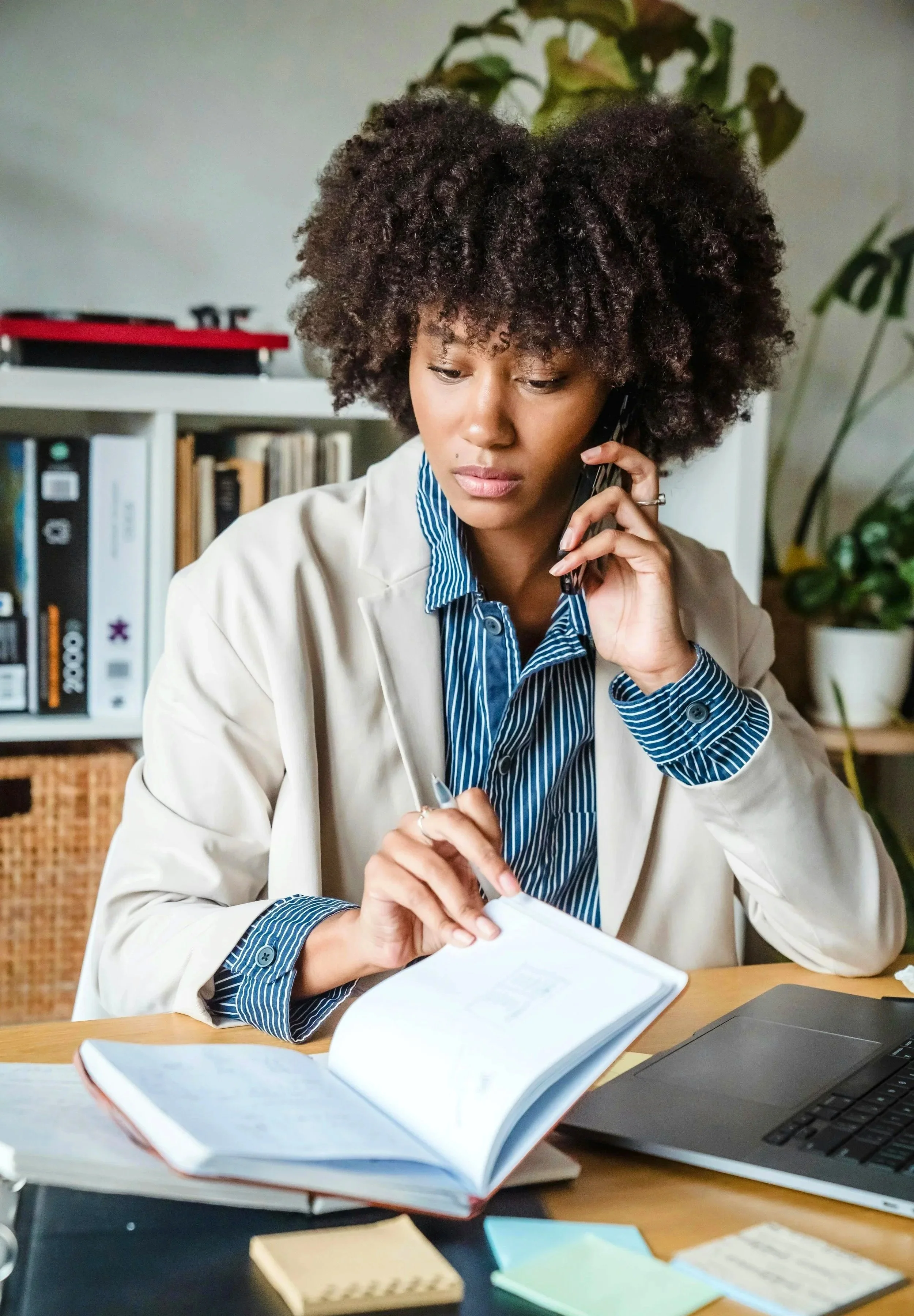 Photo of woman sitting at desk, talking on phone