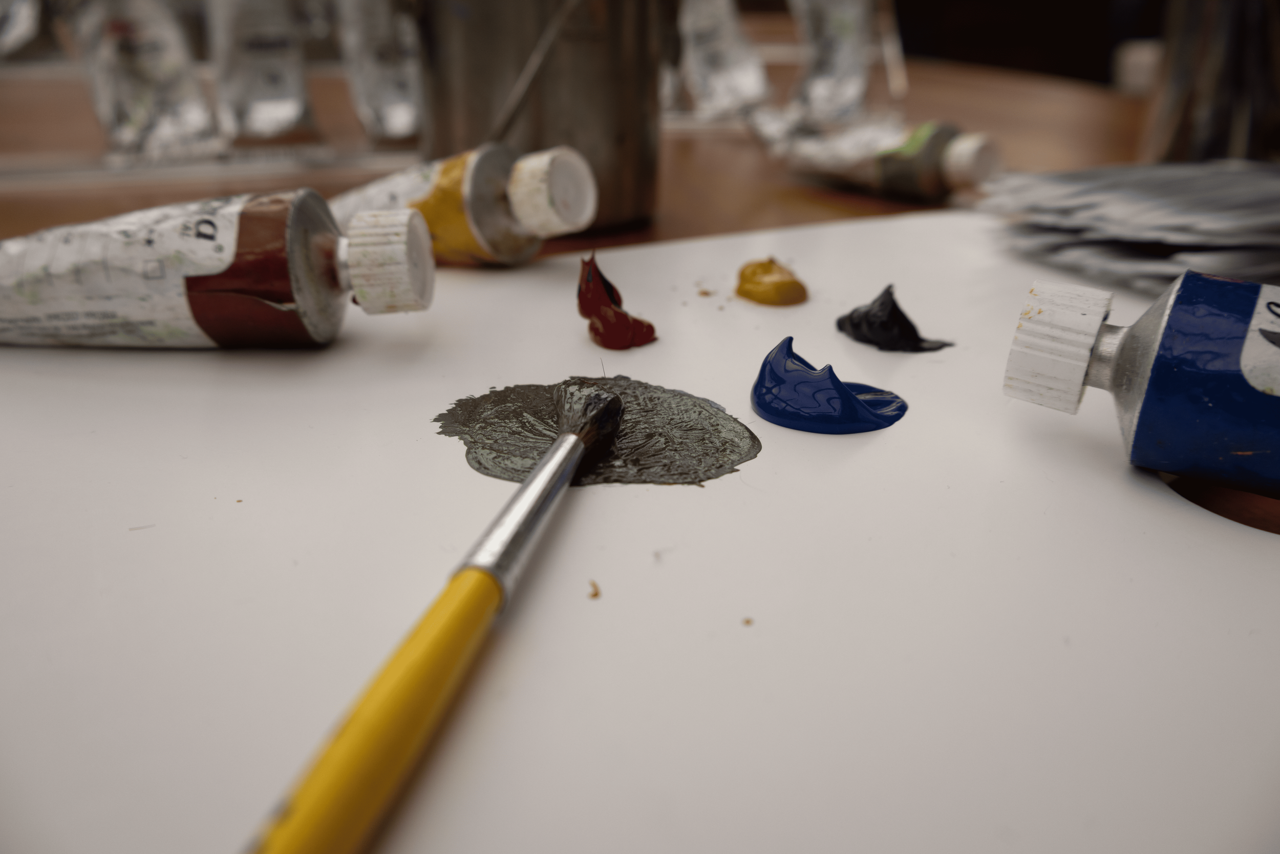 Bunte Tuben und Farbpalette mit Pinsel auf Weißer Oberfläche, Kunstmaterialien für Malerei.