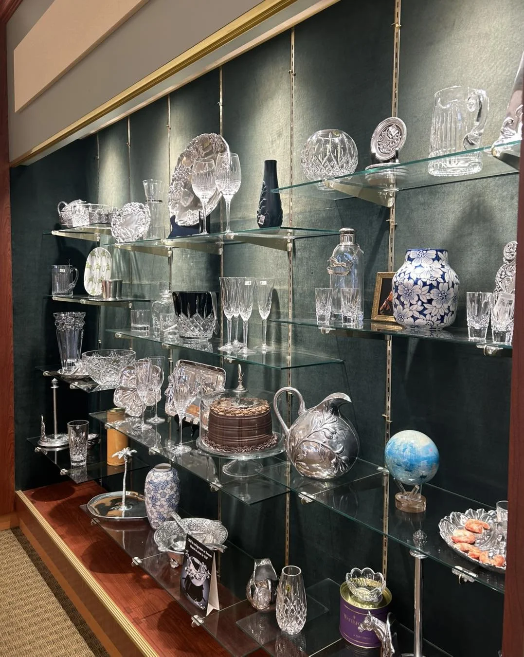 Display case filled with various decorative glassware and ceramic items, including vases, bowls, and sculptures.