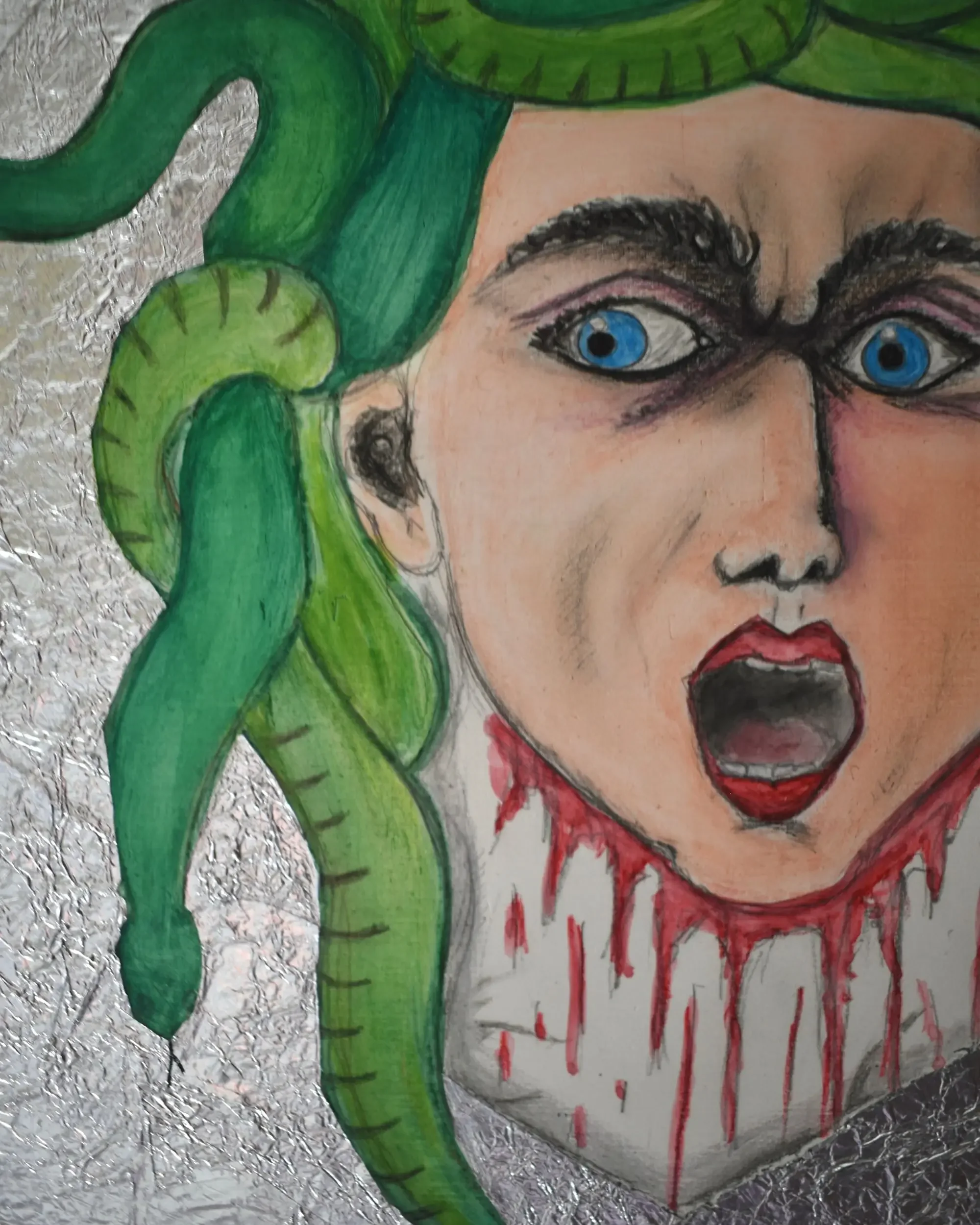 A detailed medium shot of Medusa. Mirror of Reflections., a contemporary artwork by Francesca V Kranz, capturing the frontal gaze, the expressive mouth, and the surrounding green snakes over the silver aluminum background.