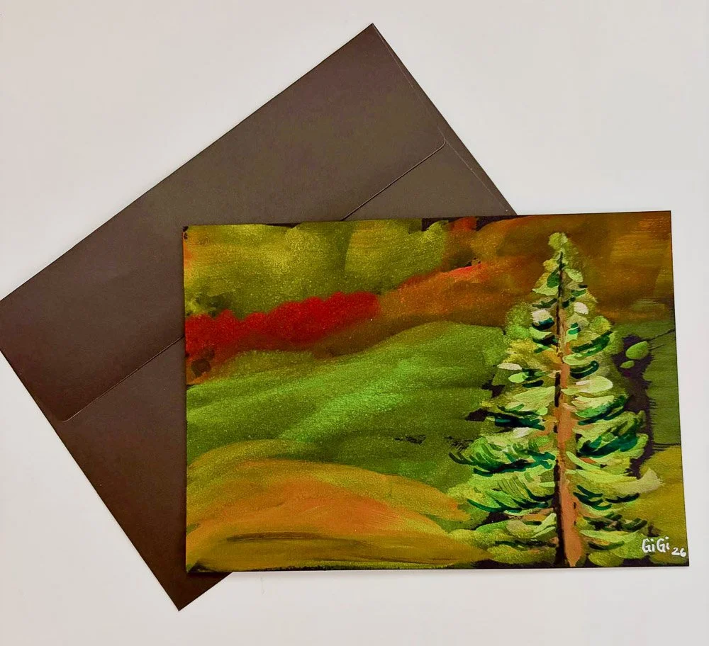 A colorful landscape painting featuring green, red, and brown hills with a pine tree in the foreground, signed by GiGi in 2026, placed on top of a brown envelope.