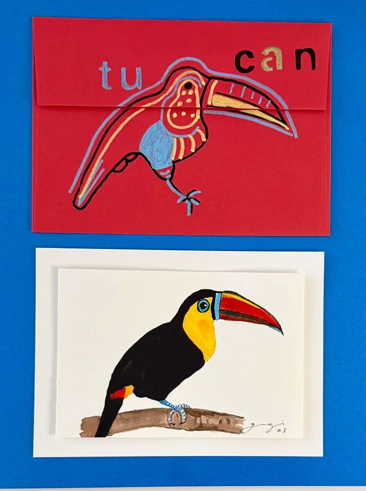 Two colorful drawings of toucans. The top drawing is an abstract, stylized toucan with bold colors and the word 'tucan' incorporated into the design, on a red background. The bottom drawing is a more realistic depiction of a toucan with a black body, yellow and blue face, and large orange beak, sitting on a branch, on a white background.