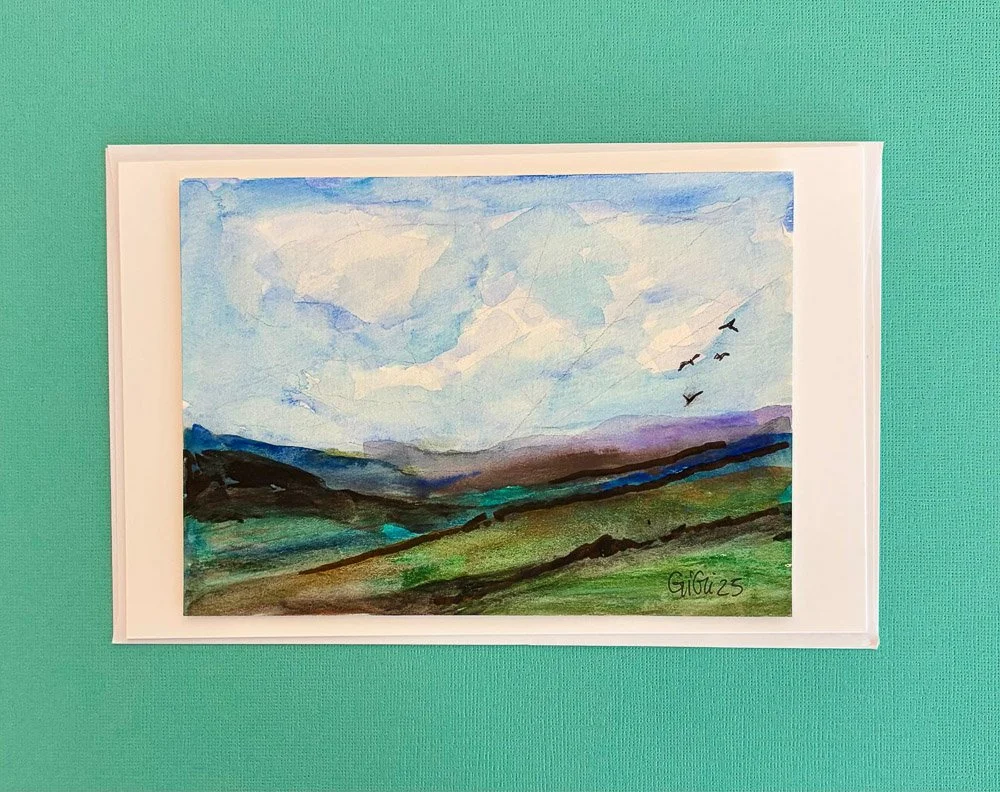 Watercolor landscape painting of green rolling hills under a blue sky with white clouds, birds flying, signed 'GIGO 23'