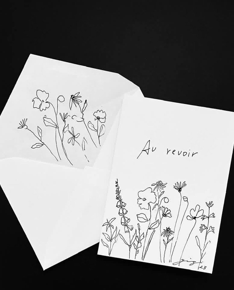 Open greeting card with hand-drawn floral illustrations and the text 'Au revoir' on the right side.