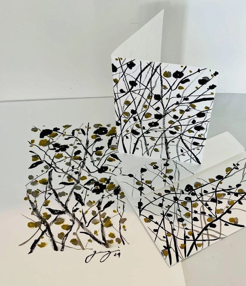 Set of art prints and cards featuring black ink botanical sketches with gold accents, displayed on a white surface.