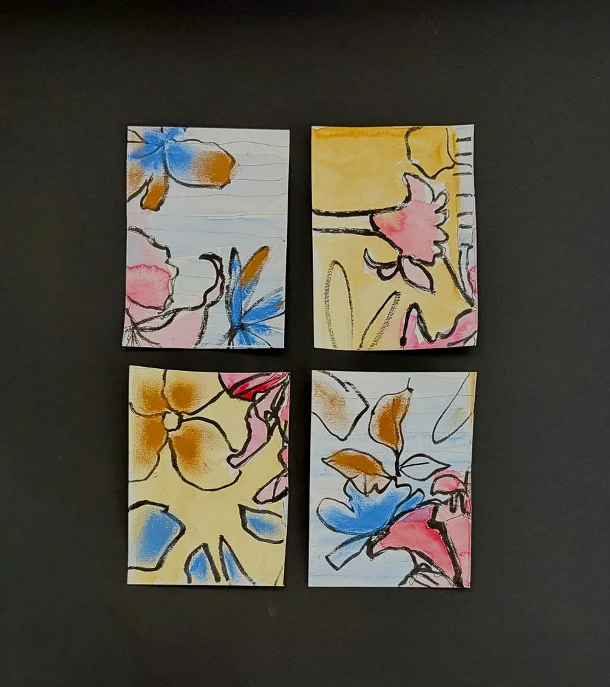 Four small pieces of lined paper with colorful abstract floral watercolor paintings, arranged in a two-by-two grid, on a black background.