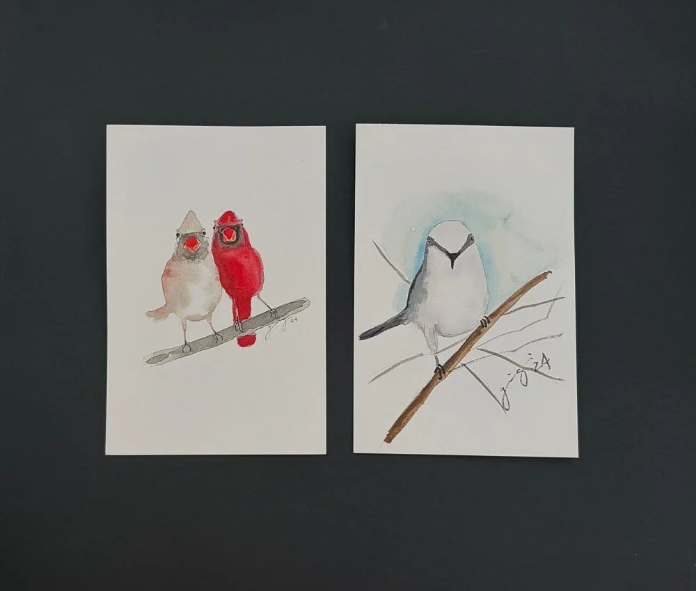 Two watercolor paintings of birds on tree branches, one with two colorful birds and the other with a single bird.